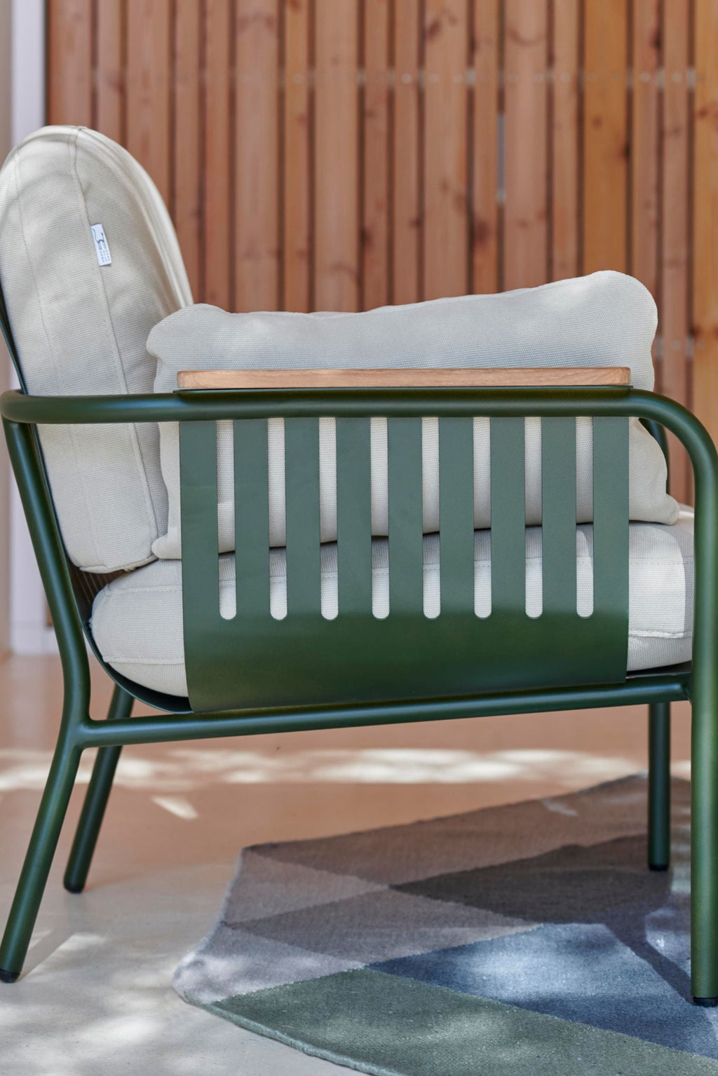 Gandia Blasco Capa 2-Seat Sofa, a modern outdoor sofa featuring a durable matte dark green aluminum frame with clean lines and distinctive slatted side panels, complemented by natural light wood armrest accents. It includes plush light beige outdoor fabric cushions, offering comfortable and stylish seating. This contemporary 2-seat patio sofa is ideal for sophisticated garden furniture, balcony seating, or expansive outdoor living spaces.