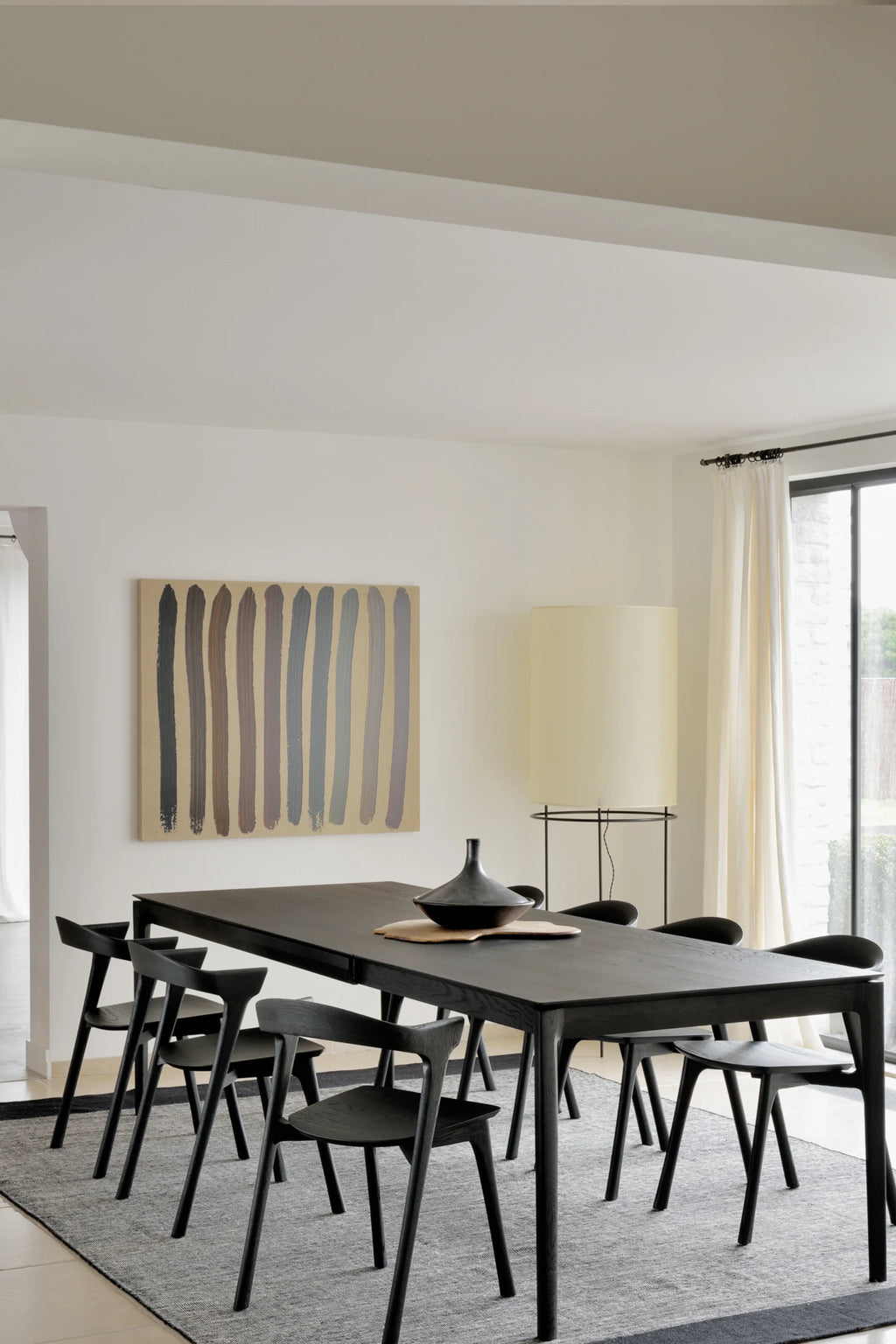 Ethnicraft Bok Extendable Dining Table, a sleek modern minimalist dining table crafted from solid dark wood with a visible grain, featuring clean lines, angled legs, and a rectangular top.