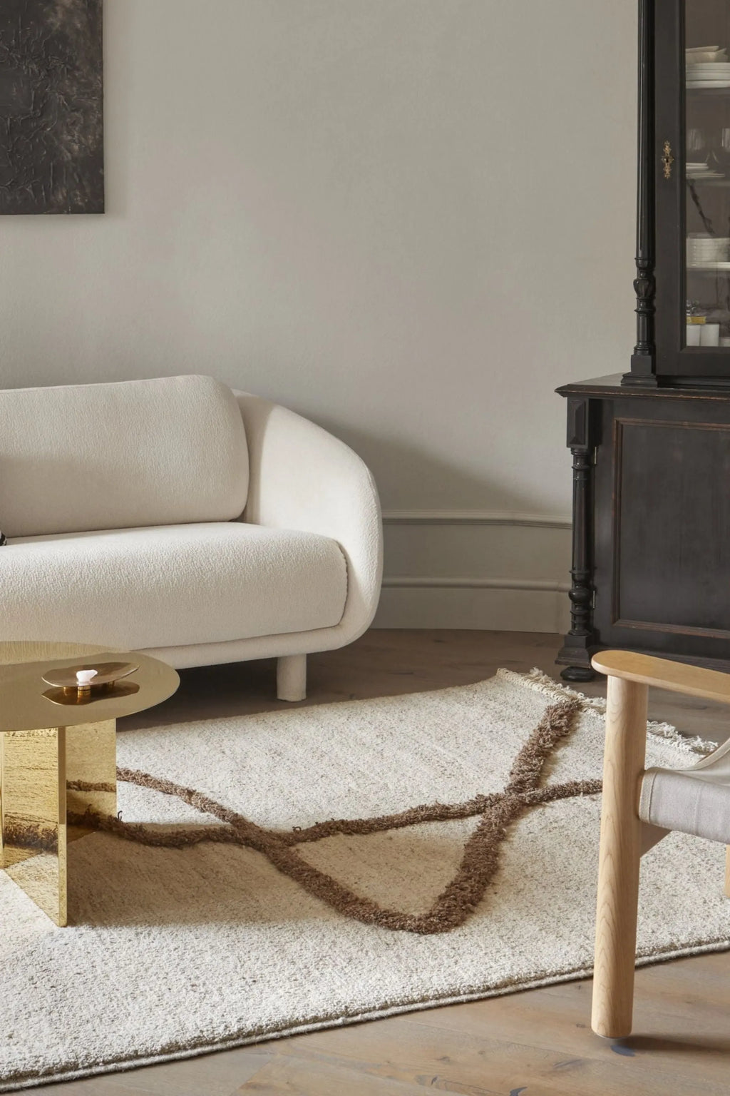 Sera Helsinki Vuoristo Rug, a textured cream wool area rug featuring an abstract organic pattern in contrasting brown shaggy pile and natural fringed edges. This hand-knotted rug offers a cozy, modern minimalist aesthetic, perfect for Scandinavian living rooms or organic modern bedrooms.