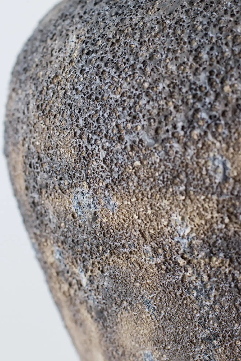 Canoa Lab Isolated n.7 Vase, a handcrafted ceramic vase with an intensely textured, porous volcanic finish in dark charcoal and earthy brown tones. This artisanal stoneware piece features a raw, organic surface resembling natural lava, giving it a brutalist yet minimalist aesthetic. Perfect for organic modern shelf styling or as a statement piece in contemporary interiors.