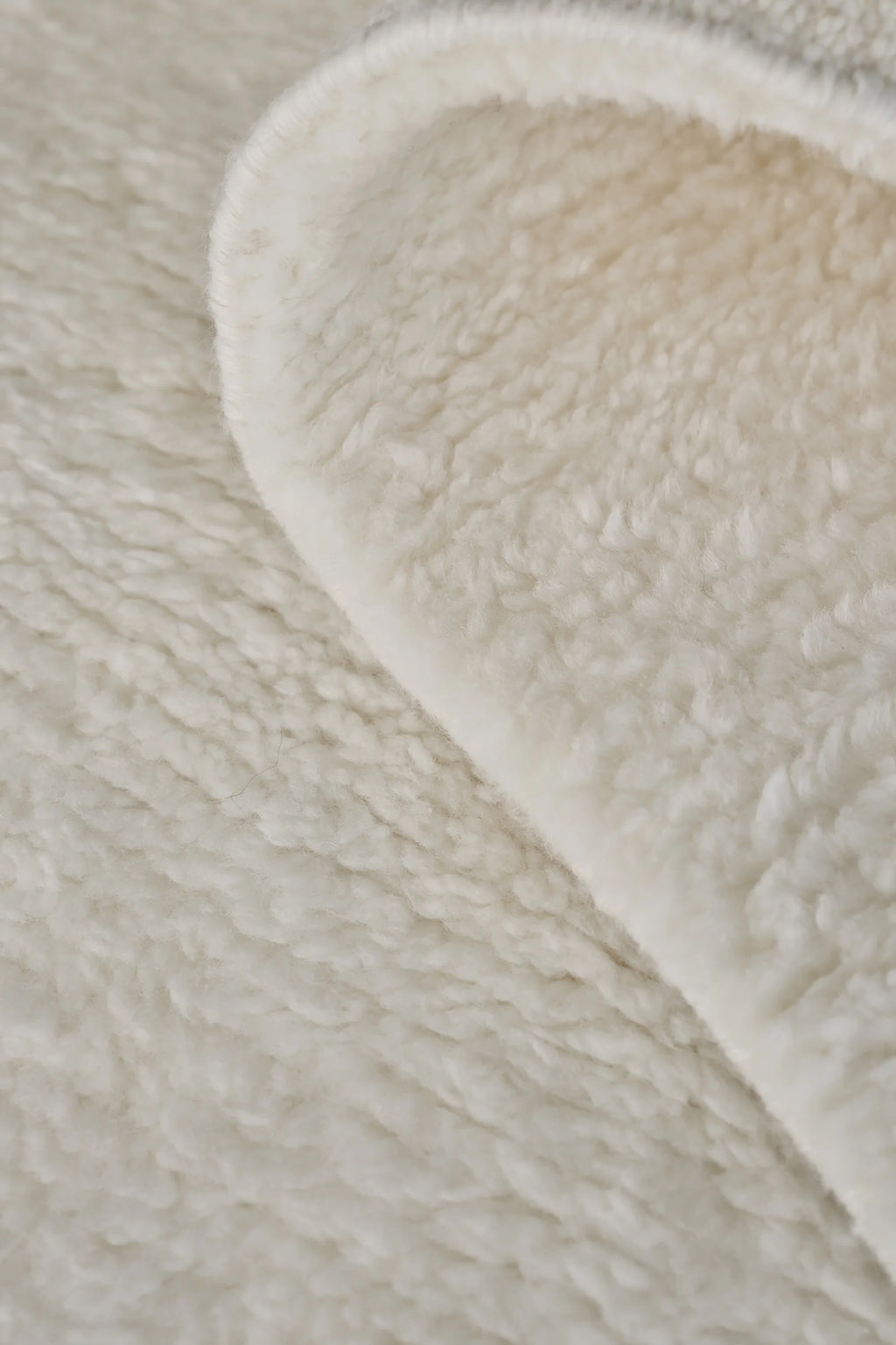 Linie Design Soft Savannah Wool Rug, a luxurious cream-colored wool rug featuring an incredibly plush, deep-pile texture and soft, shaggy feel, showcasing natural ivory tones. This cozy Scandinavian wool rug is perfect for adding warmth and comfort to minimalist living rooms, organic modern bedrooms, or creating a comfortable hygge reading nook.