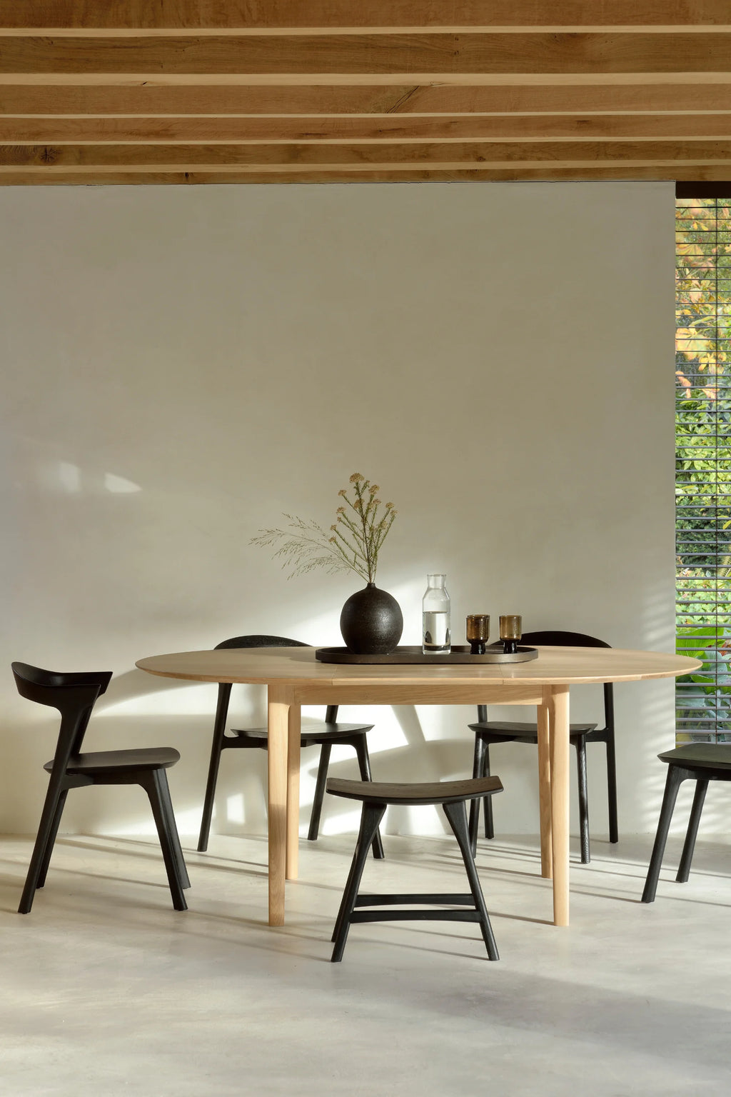 Ethnicraft Bok Extendable Dining Table, a beautifully crafted solid oak oval dining table with a natural light wood finish and elegant tapered legs, designed for modern minimalist and Scandinavian interiors. This versatile extendable dining table is perfect for contemporary dining rooms and organic modern spaces.