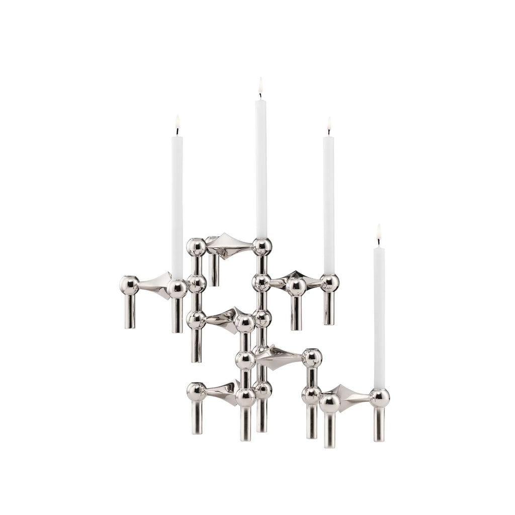 Stoff Nagel Modular Candle Holder - Chrome - Configuration 2, an iconic mid-century modern design crafted from polished chrome metal with a reflective silver finish, featuring an intricate sculptural arrangement of interconnected spheres and cylinders holding four white taper candles. This versatile Danish design candelabra is perfect for creating a striking dining table centerpiece or a unique shelf styling accent in contemporary living rooms.