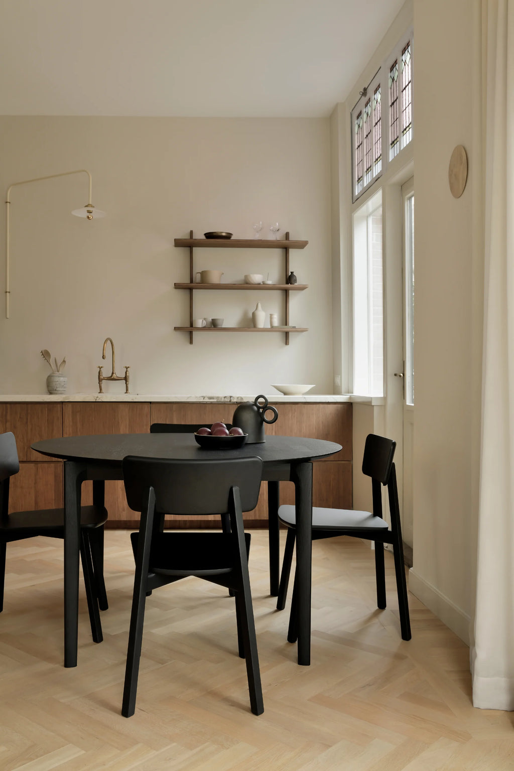 Ethnicraft Bok Extendable Dining Table, a sleek modern minimalist dining table crafted from solid oak with a sophisticated matte black finish and subtly tapered legs. This contemporary round dining table offers seamless extension for versatile dining and entertaining. Ideal for Scandinavian dining rooms or modern kitchen spaces seeking elegant, functional furniture.