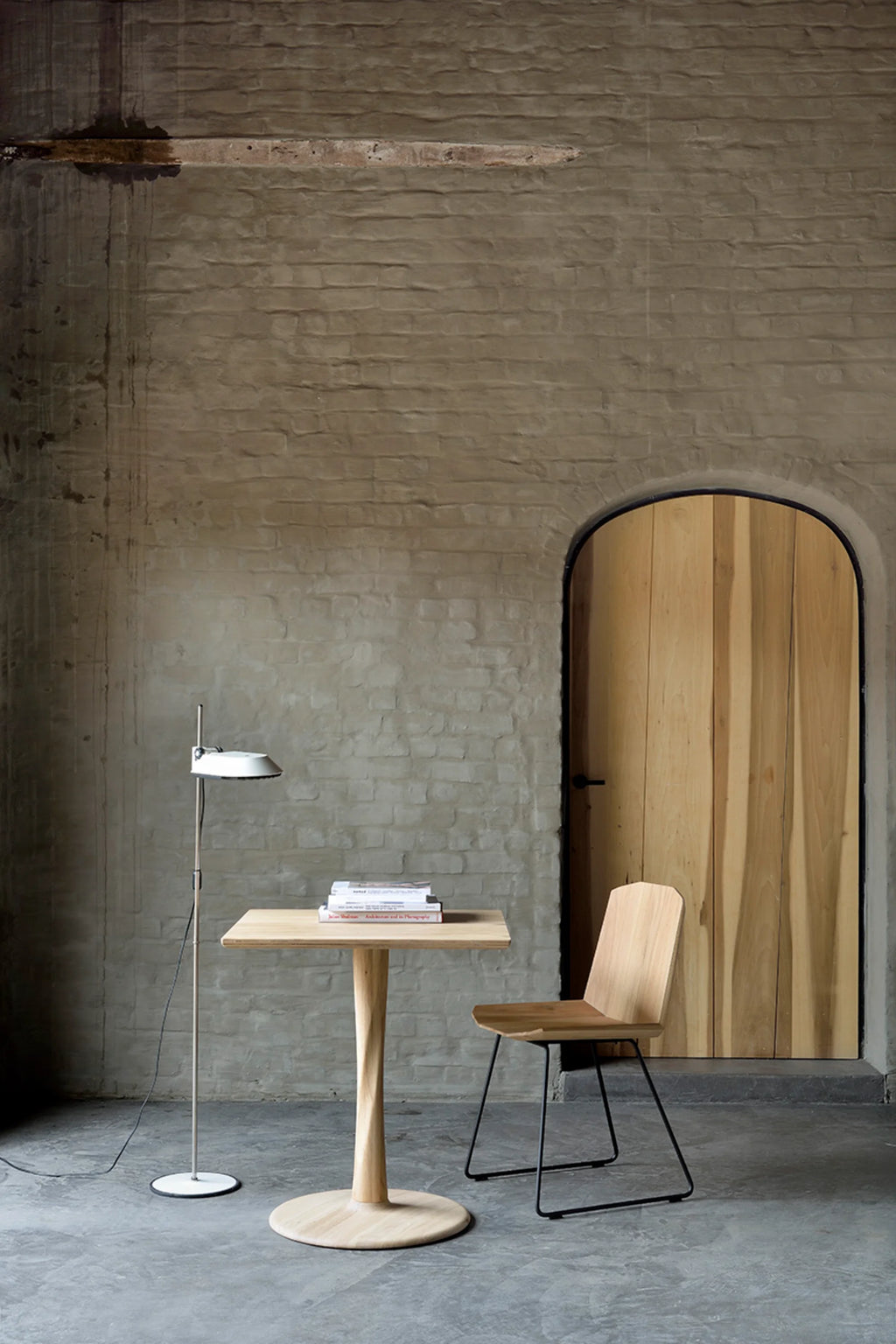 Ethnicraft Torsion Dining Table, a solid natural oak square dining table featuring a unique twisted pedestal base and a sturdy round base plate, showcasing a light wood tone and smooth grain. This organic modern and minimalist table is perfect for small dining rooms, Scandinavian kitchen nooks, or as a contemporary accent piece.