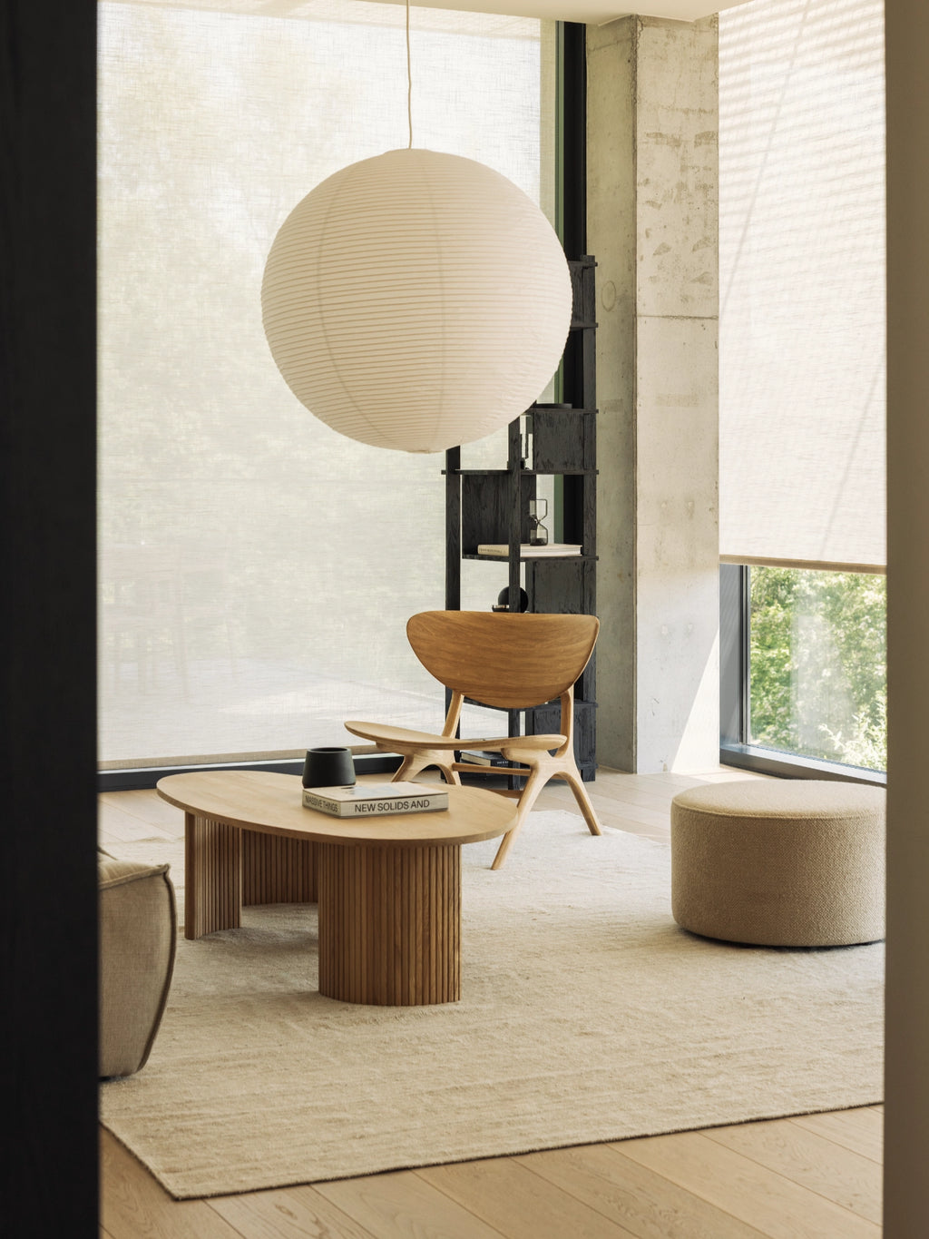 Ethnicraft Barrow Pouf, a round contemporary pouf upholstered in a soft, natural beige bouclé fabric with a subtle textured finish and a clean cylindrical shape. This versatile ottoman is perfect as a footrest or extra seating for minimalist living rooms or Scandinavian-inspired bedrooms.