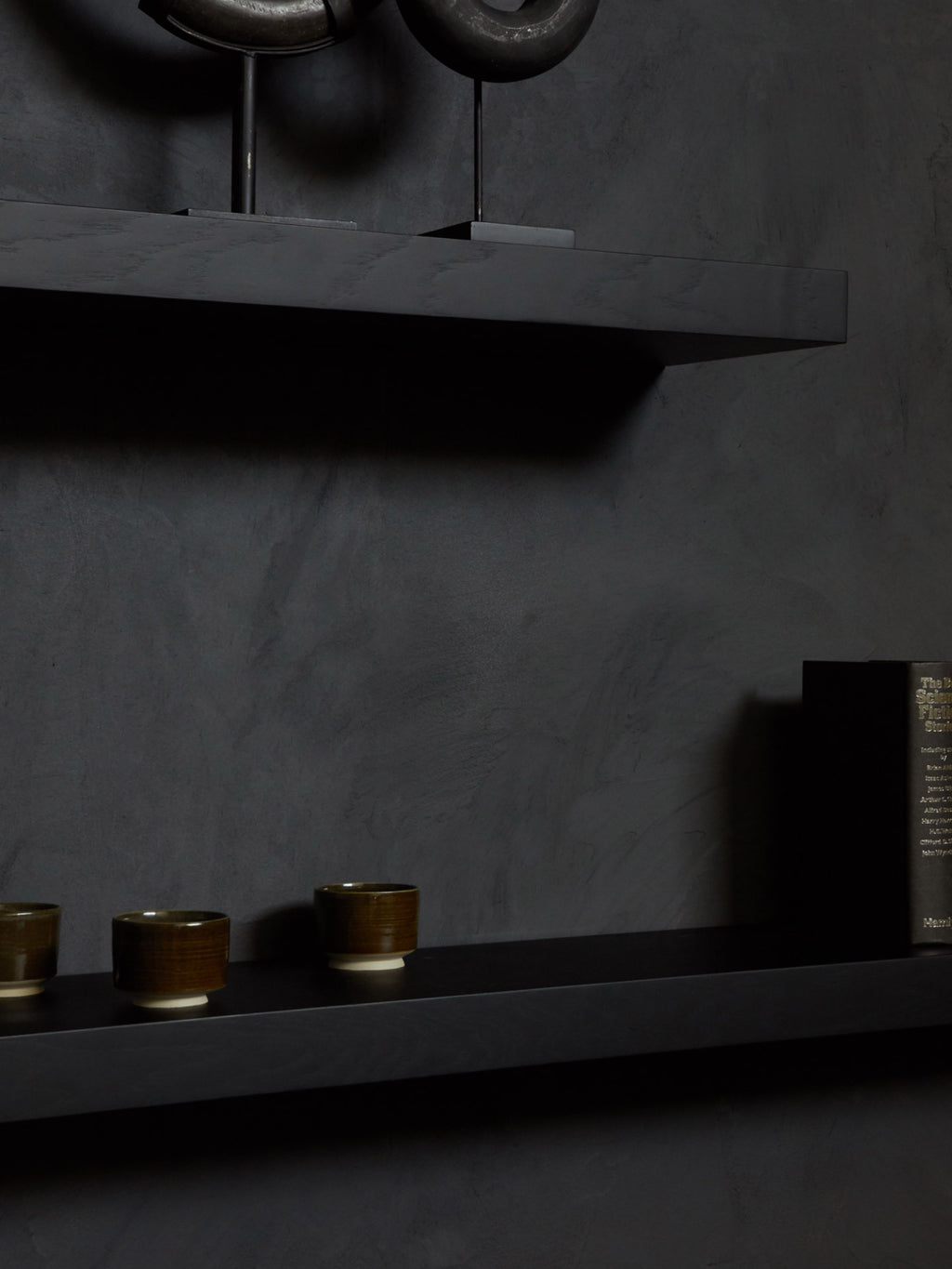 Ethnicraft Wall Shelf, a sleek modern minimalist floating shelf crafted from dark solid wood with a matte black finish and subtle wood grain texture. Its clean, rectangular silhouette offers a contemporary storage solution for any room. Ideal for Scandinavian living rooms, modern bedrooms, or minimalist home office shelf styling.