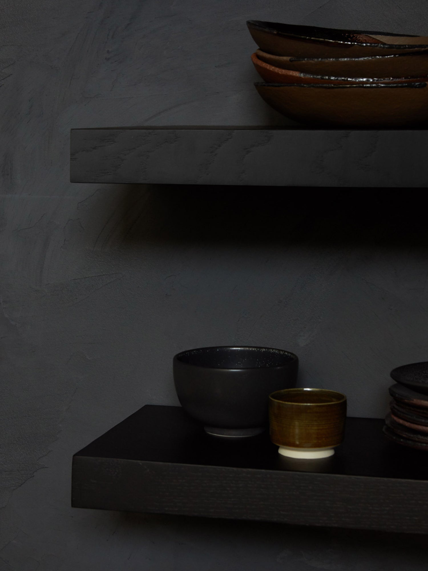 Ethnicraft Wall Shelf, a sleek modern minimalist floating shelf crafted from dark solid wood with a subtle visible grain and a deep charcoal finish. This contemporary rectangular display shelf, set against a textured dark grey wall, is perfect for minimalist living room decor, industrial chic home offices, or elegant bedroom accent styling.