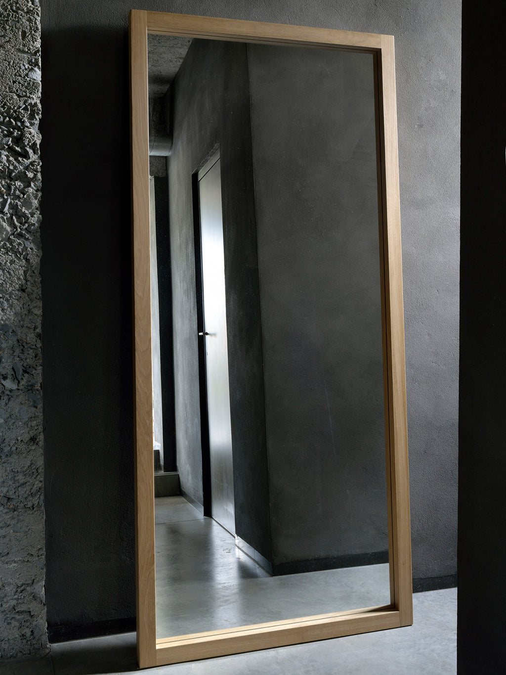 Ethnicraft Light Frame Floor Mirror, a tall rectangular full-length mirror featuring a slender frame crafted from natural solid oak with a smooth, light wood finish, embodying a modern minimalist design. Perfect as a contemporary floor mirror for living rooms, bedrooms, or entryways in Scandinavian-inspired homes.