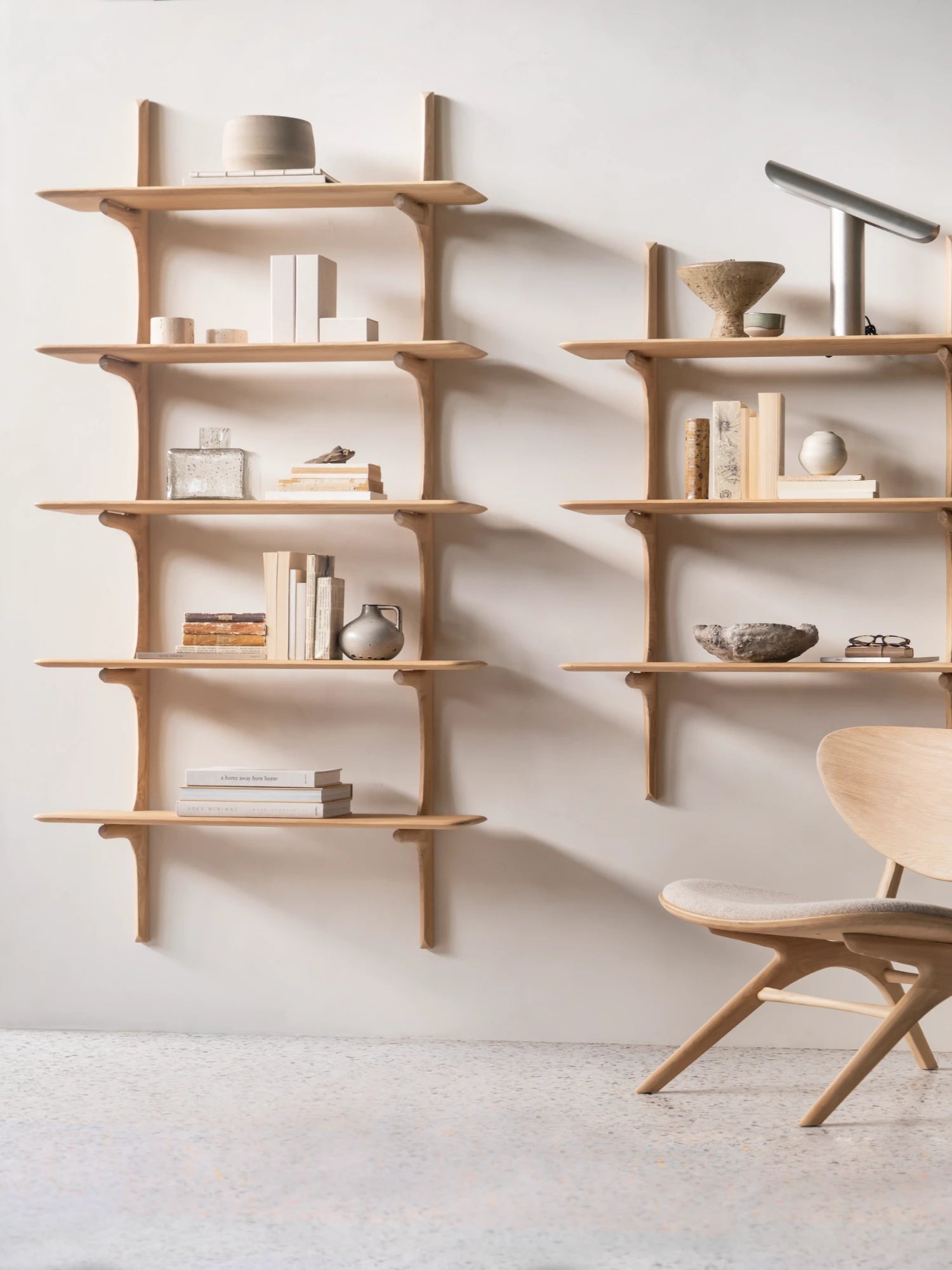 Ethnicraft PI Wall Shelf, a light natural solid oak wall-mounted shelving unit featuring an organic modern design with beautifully curved shelves and integrated support brackets. This minimalist and Scandinavian-inspired wooden bookcase is ideal for stylish display and storage in a contemporary living room, bedroom, or home office.