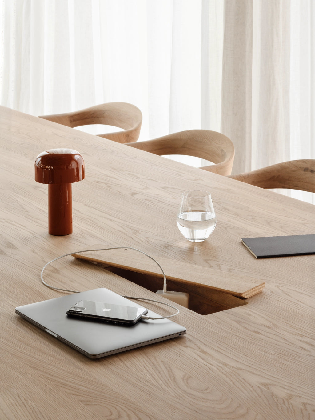 Ethnicraft Geometric Meeting Table, a modern minimalist dining table crafted from light solid oak wood with a smooth natural grain and clean rectangular silhouette. This versatile table features an innovative integrated cable management system with a discreet lidded compartment. Ideal as a Scandinavian dining table, contemporary home office desk, or collaborative meeting table for design-conscious interiors.