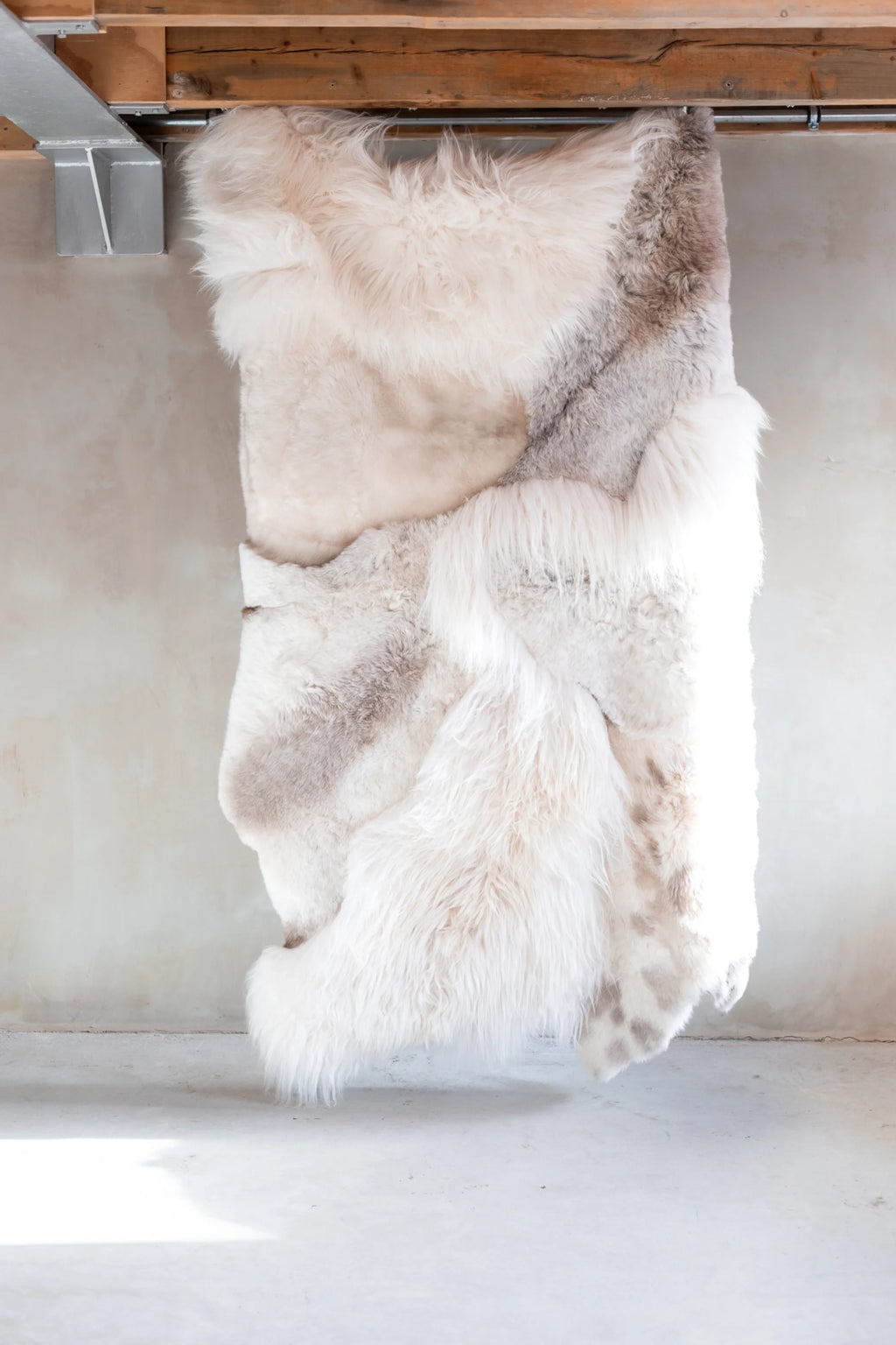 White fur throw hanging under a wooden shelf