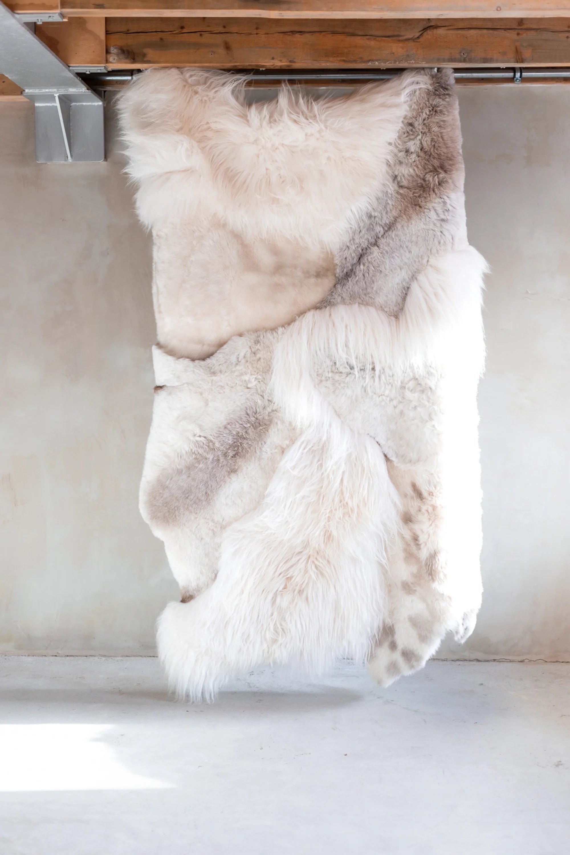 White fur throw hanging under a wooden shelf