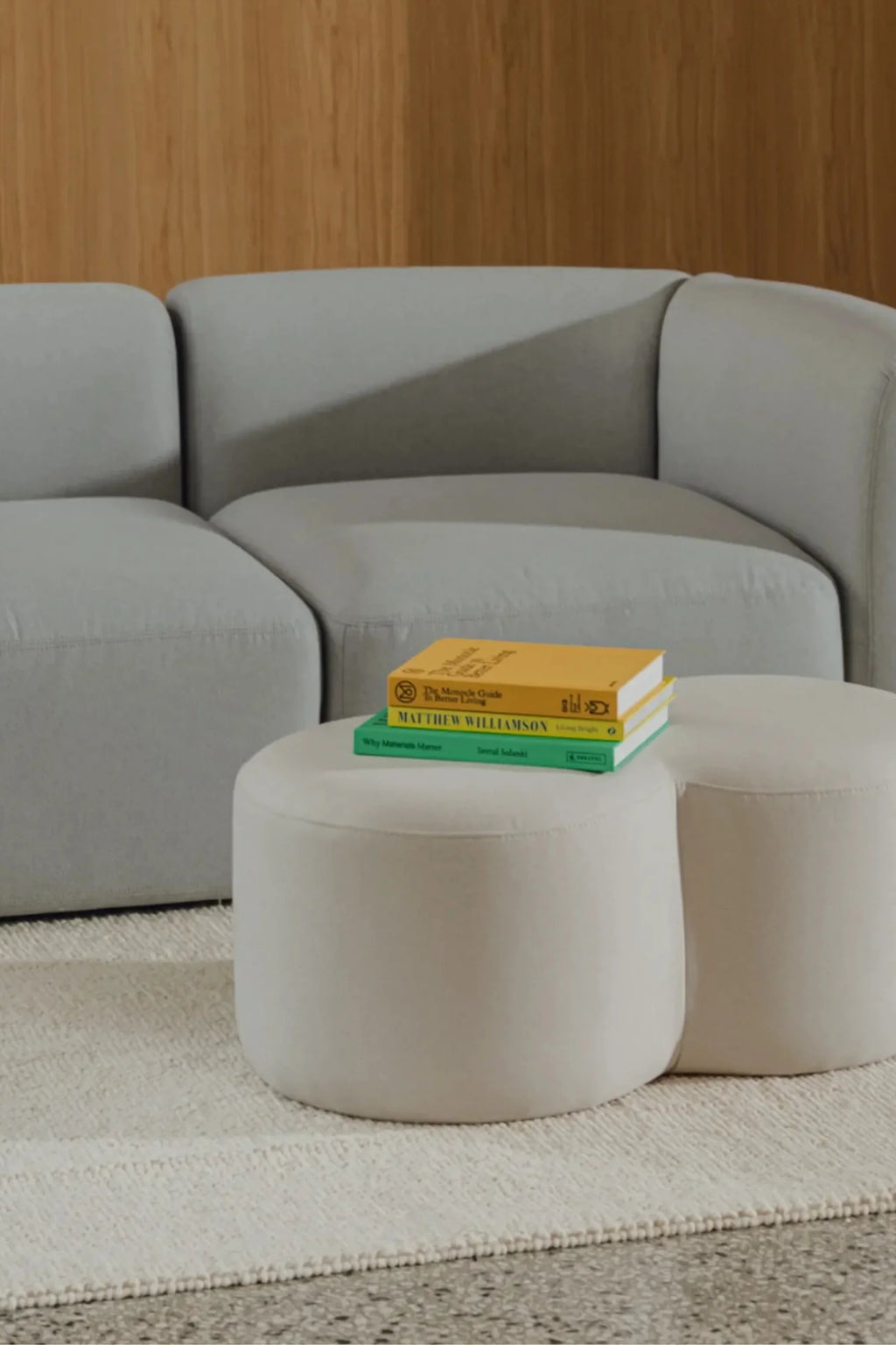 noo.ma Flom Corner Sofa, a contemporary modular sofa featuring a soft light grey upholstered fabric with a plush, inviting texture and distinct rounded, organic silhouette. This low-profile corner sectional offers deep seating and a modern minimalist design. Ideal for stylish living rooms seeking an organic modern aesthetic or Scandinavian-inspired comfort.