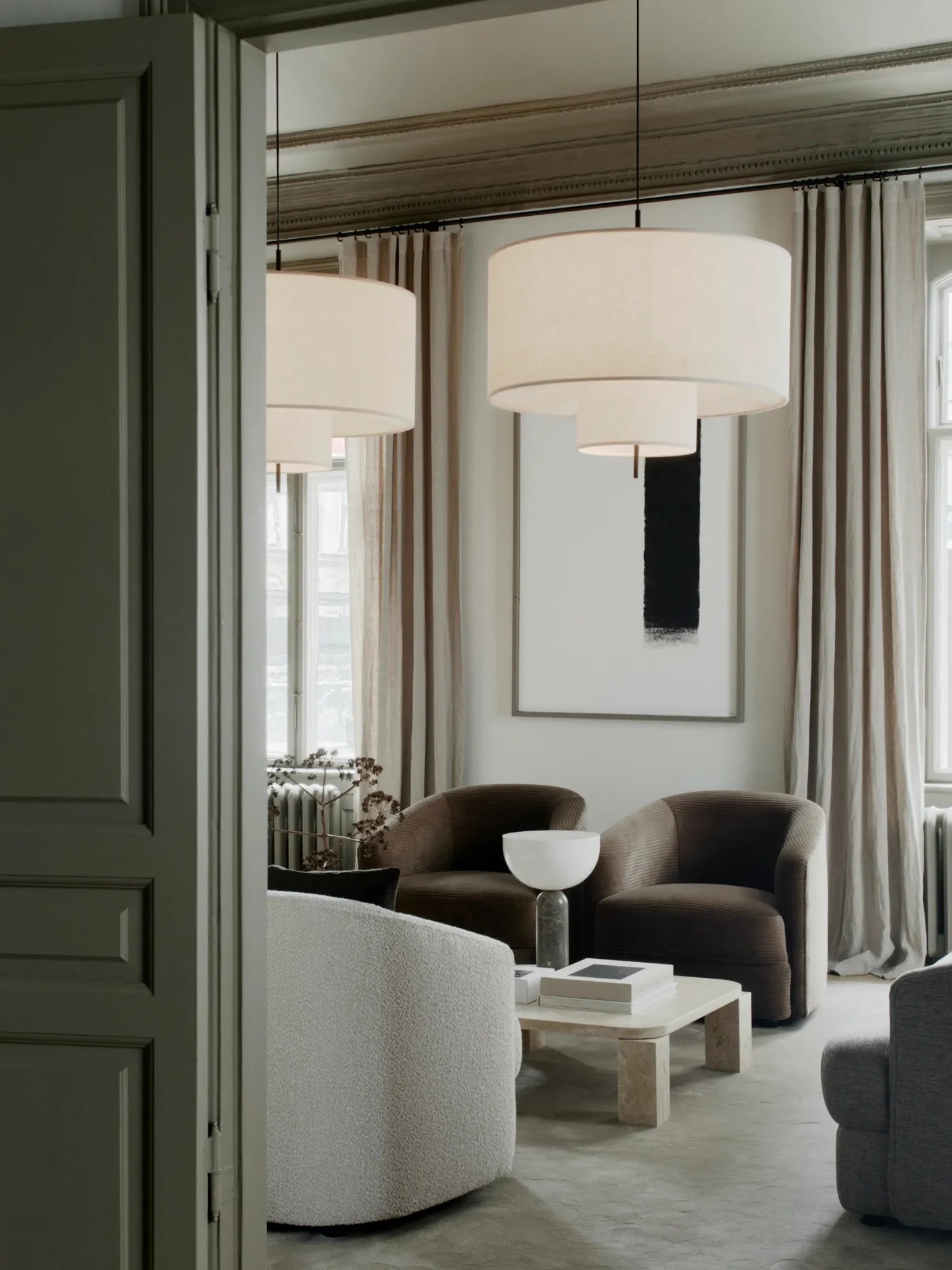 New Works Margin Pendant Lamp, featuring a layered, cream fabric drum shade in a modern living room setting. This designer ceiling light exudes premium sophistication. Ideal for ambient lighting.