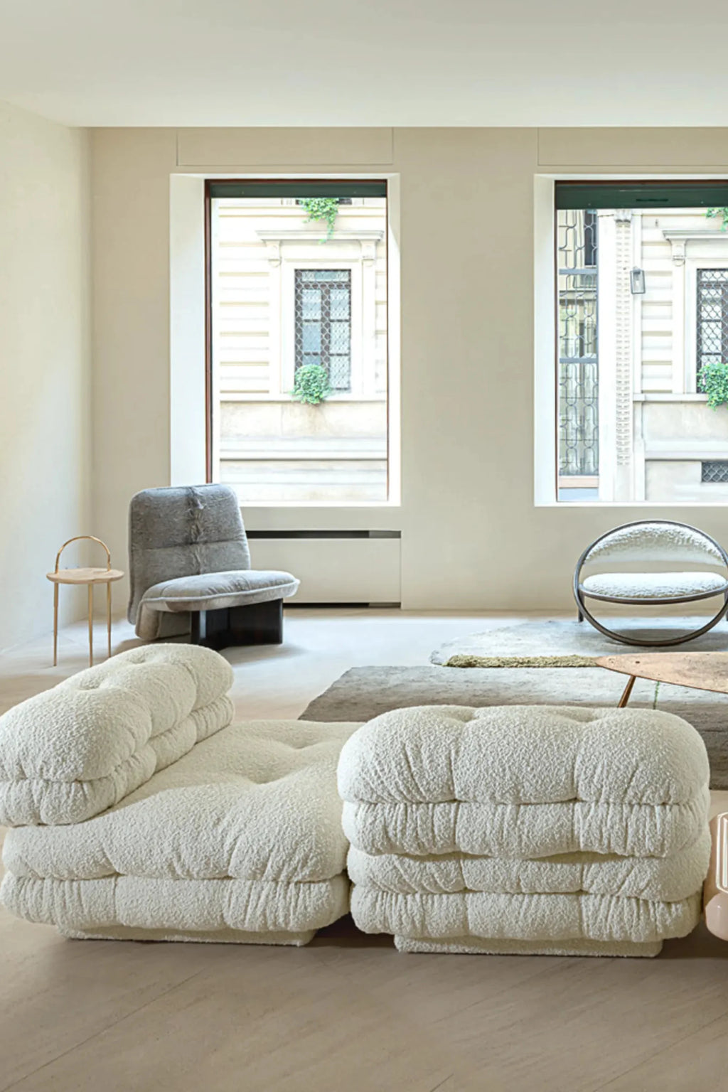 Hessentia Lowell Modular Sofa, a luxurious two-piece modular sofa upholstered in a creamy off-white bouclé fabric with a plush, deeply textured finish and distinctive tufted details. Its low-profile, organic shape and generous deep seating create an inviting cloud-like aesthetic, perfect for contemporary minimalist living rooms or cozy modern lounge spaces.