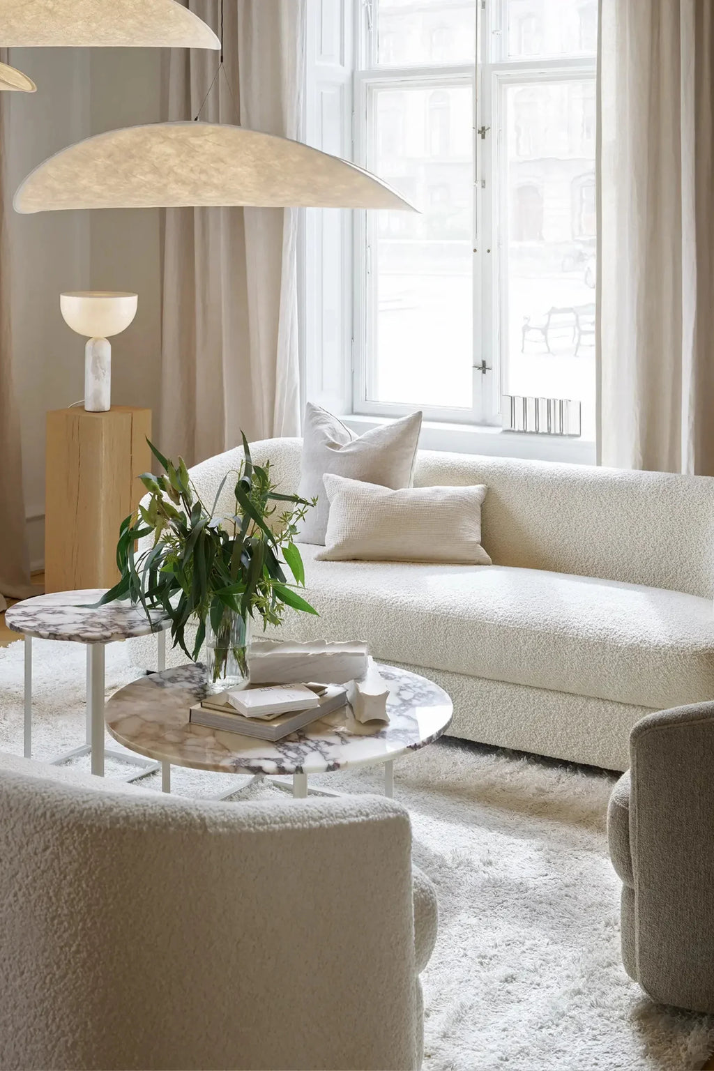 New Works Covent Sofa Deep 3-Seater, a luxurious curved bouclé sofa upholstered in a soft, textured cream fabric with a deep seating profile and organic modern silhouette. This contemporary 3-seater sofa offers plush comfort and minimalist elegance, perfect for Scandinavian living rooms or organic modern interiors.