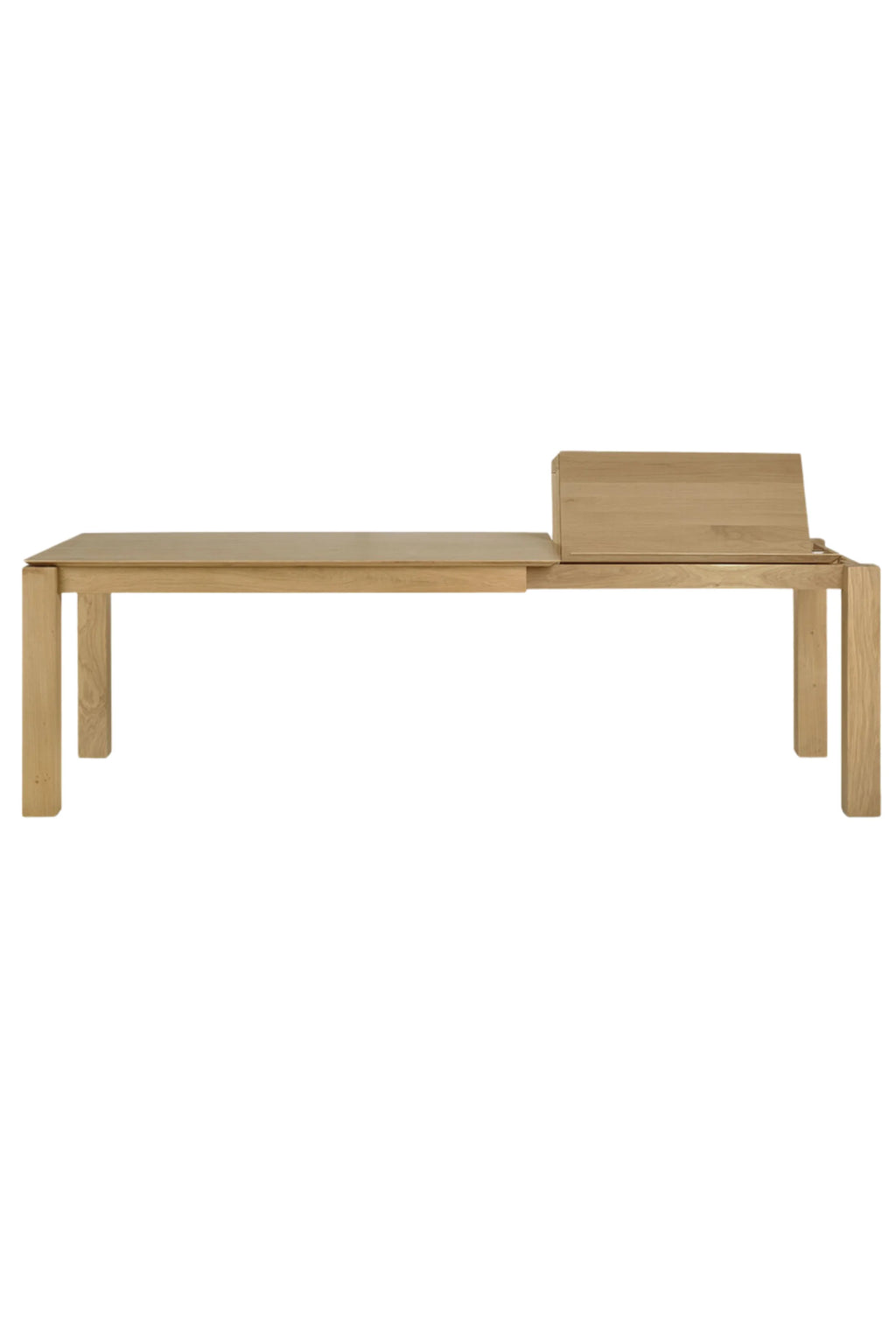 Ethnicraft Slice Extendable Dining Table, a modern minimalist dining table crafted from natural solid oak wood with a light, warm finish and clean, rectangular lines. This contemporary oak dining table features an innovative integrated self-storing leaf, visible folded up at one end, for easy extension. Ideal for Scandinavian dining rooms or modern kitchens seeking versatile, high-quality furniture.