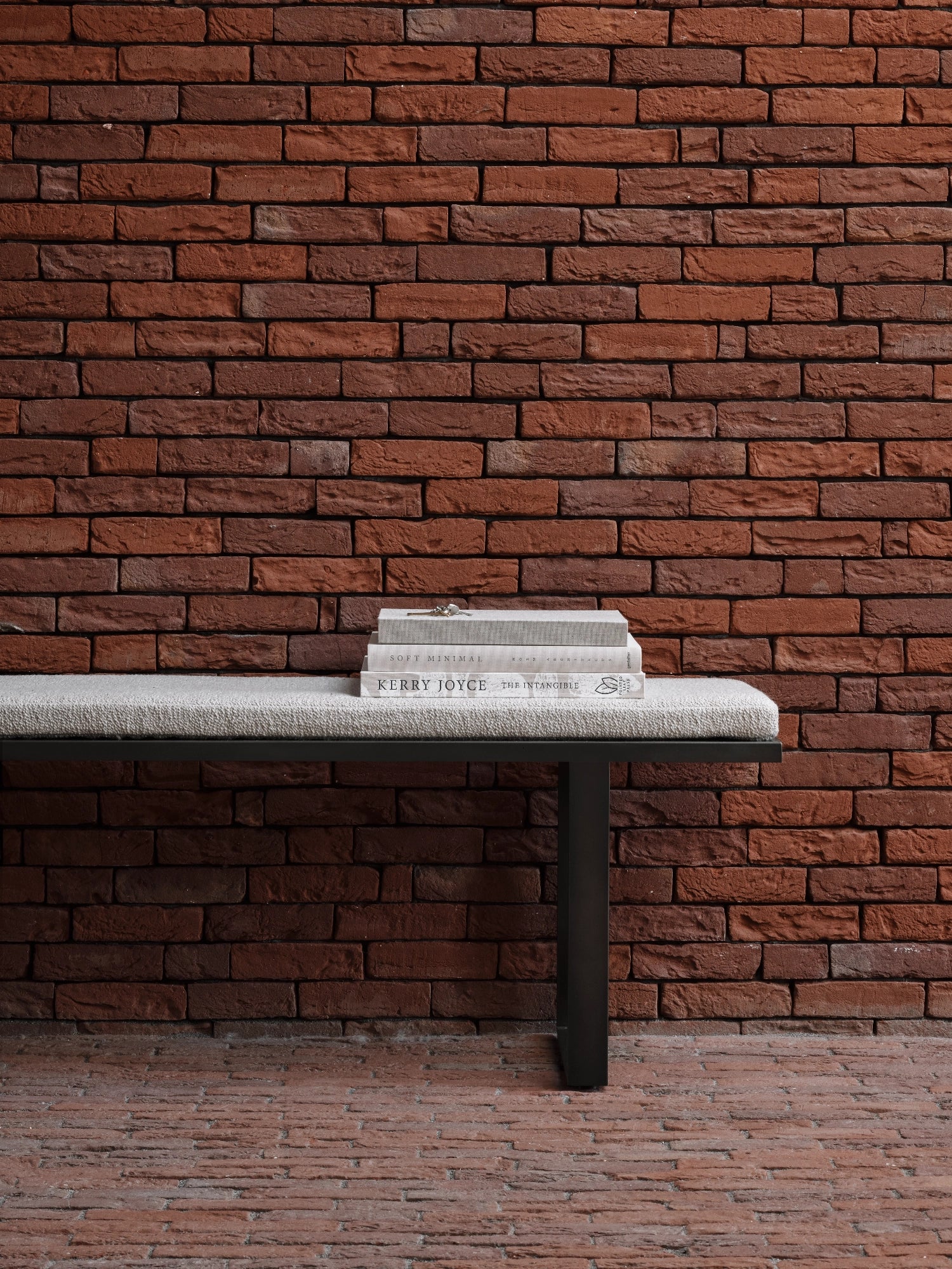 Ethnicraft Stability Bench, a sleek modern minimalist bench featuring a rectangular seat upholstered in a textured light grey fabric, supported by a sturdy matte black metal frame with clean, geometric lines. This contemporary upholstered bench is ideal for stylish entryway seating, a living room accent, or as a functional bedroom bench in modern or industrial chic interiors.