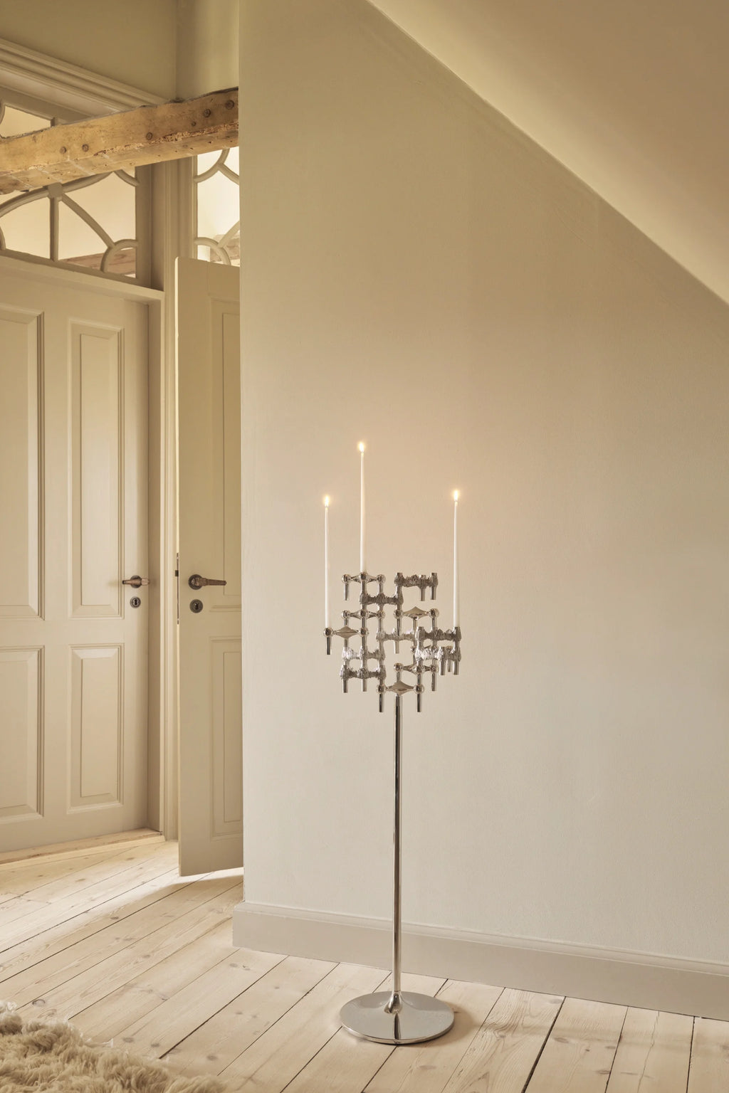 Stoff Nagel Quist Candle Holder, a striking mid-century modern floor candelabra crafted from polished chrome-plated metal, featuring a modular, interlocking geometric design that holds multiple white tapered candles.