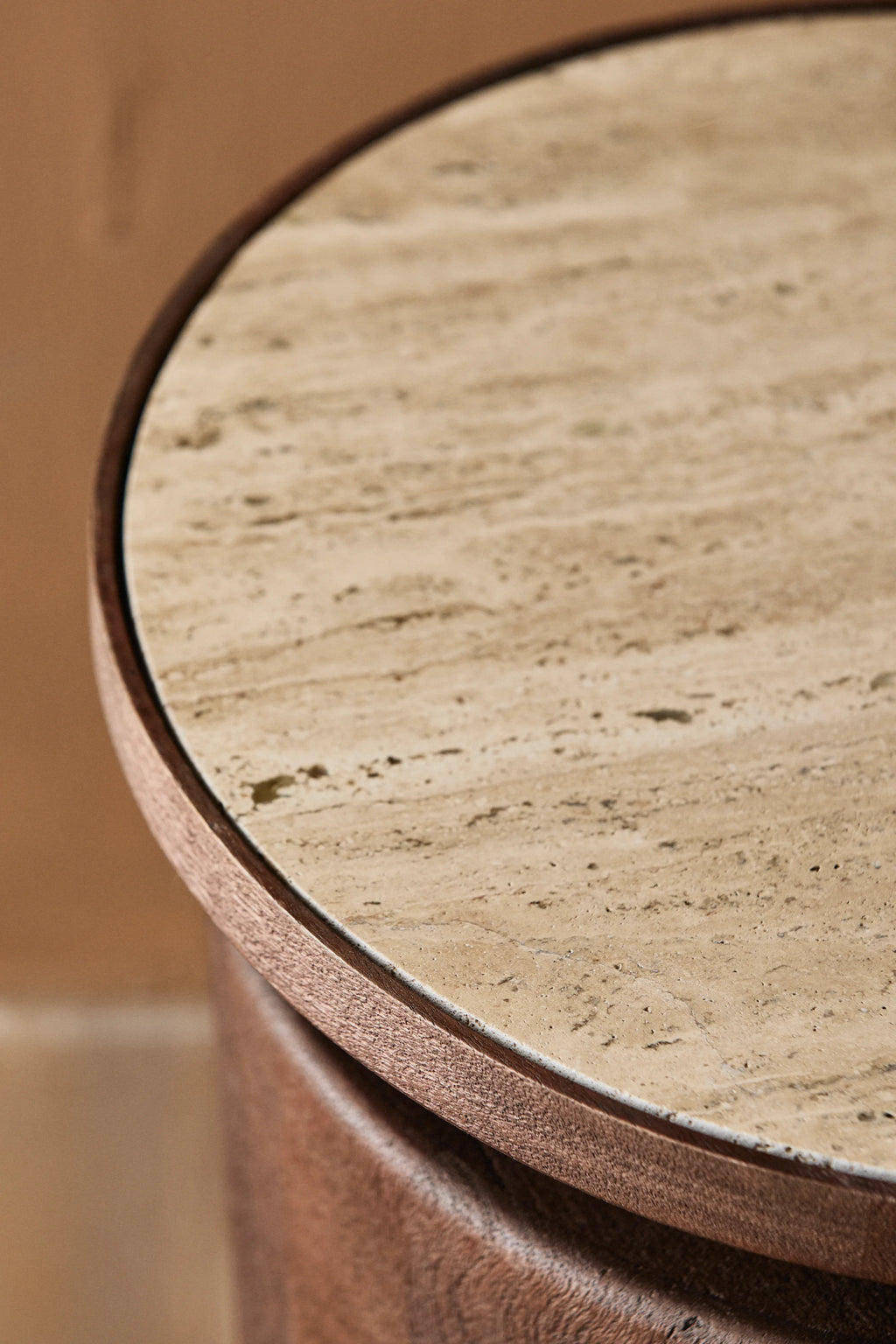 Nordal Kwando Side Table, a sophisticated organic modern accent table featuring a round light beige travertine top with a natural porous texture and distinctive veining, set within a rich dark brown wood frame and cylindrical base. This contemporary wood and travertine side table is ideal for adding a touch of rustic luxury to living rooms, bedrooms, or entryways.