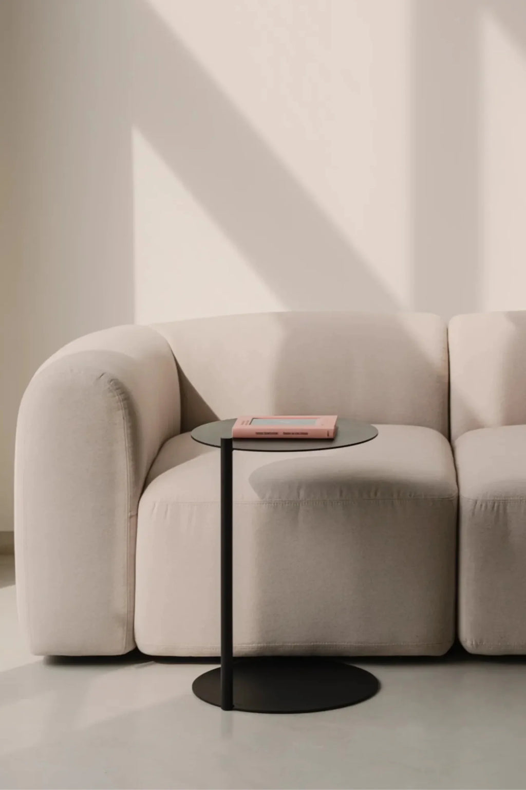 noo.ma Flom Corner Sofa, a plush modern minimalist corner sofa upholstered in a light beige textured fabric, featuring a gently curved organic silhouette, rounded arms, and deep, comfortable seating. Ideal for contemporary living rooms, organic modern interiors, or Scandinavian-inspired spaces.