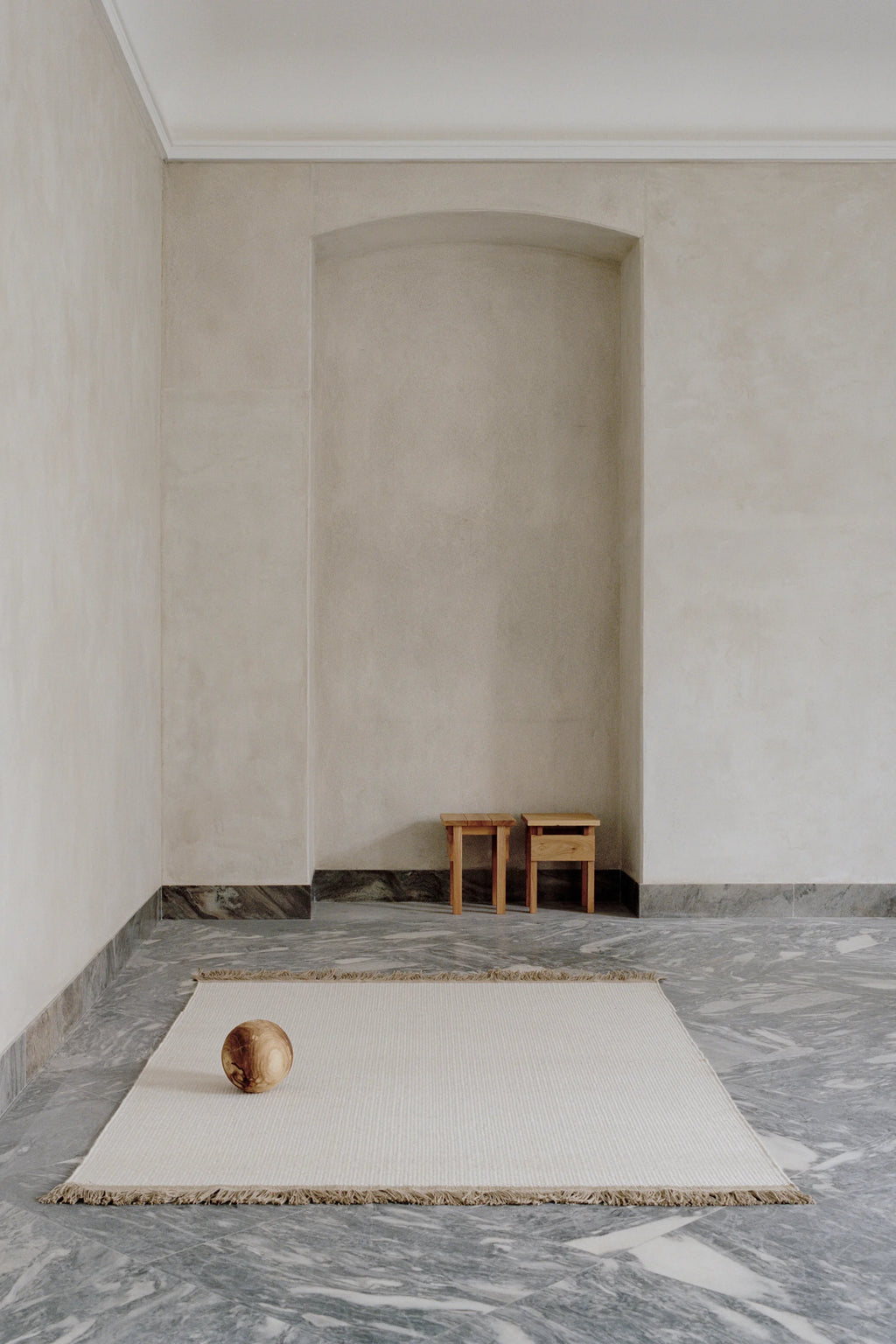 Linie Design Pastoral Unity Wool Rug, a natural undyed cream wool flatweave area rug featuring a subtle ribbed texture and soft fringed edges. This minimalist Scandinavian design offers a neutral aesthetic, perfect for adding warmth and organic texture to modern living rooms, bedrooms, or japandi-inspired spaces.