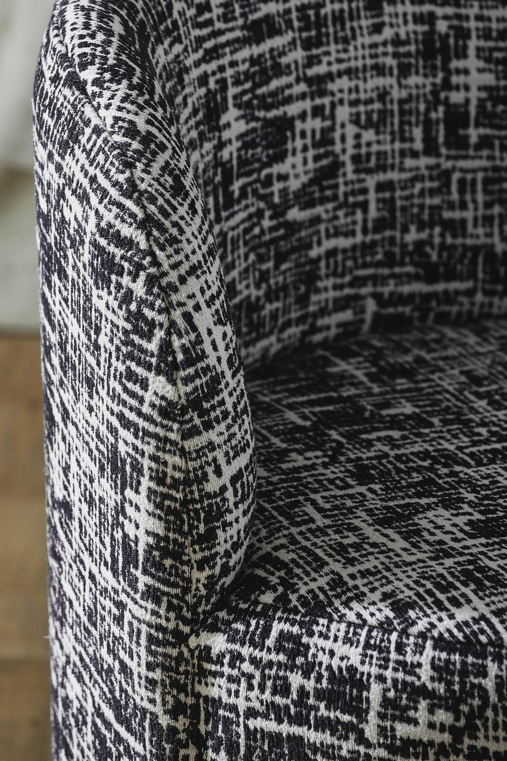 Nordal Bomu Lounge Chair, featuring a dynamic black and white woven fabric upholstery with an abstract, textured grid pattern and a gracefully curved armrest.