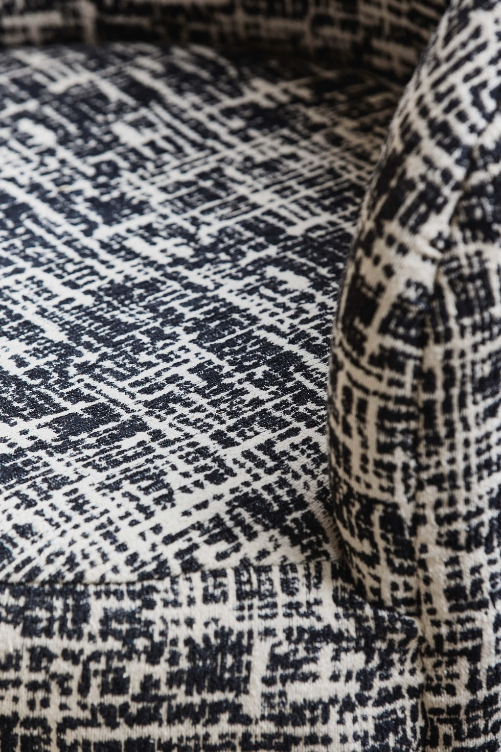 Nordal Bomu Lounge Chair, featuring a striking black and off-white abstract pattern upholstery on a plush, textured woven fabric. This contemporary lounge chair showcases an organic, distressed geometric design that adds depth and visual interest to its inviting form.
