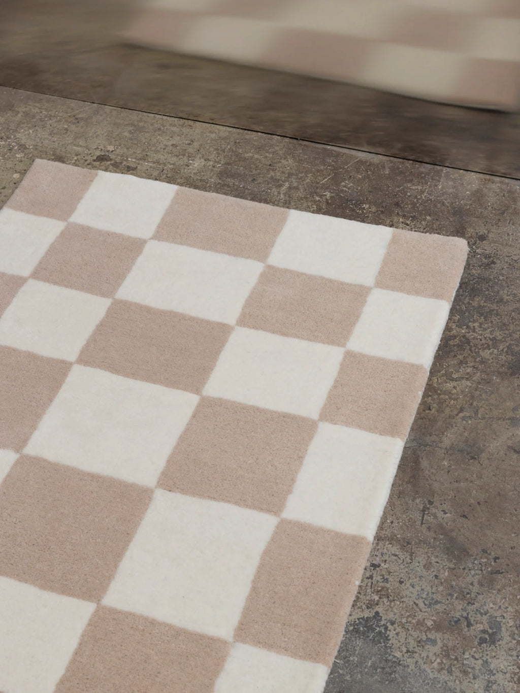 Tinted Objects Hafstrom Wool Runner Rug, featuring a soft, plush checkerboard pattern in natural ivory and light beige hues. This stylish and durable wool runner rug is perfect for adding warmth and modern elegance to hallways or entryways for contemporary home decor enthusiasts.