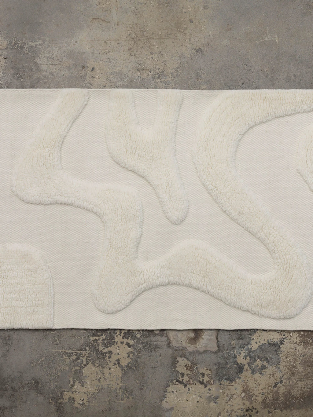 Tinted Objects Norlander Wool Runner Rug, a luxurious cream-colored wool runner rug featuring an organic, abstract raised texture pattern on a flat-woven base. This stylish and durable rug is perfect for adding warmth and modern design to hallways or entryways for contemporary home decor enthusiasts.