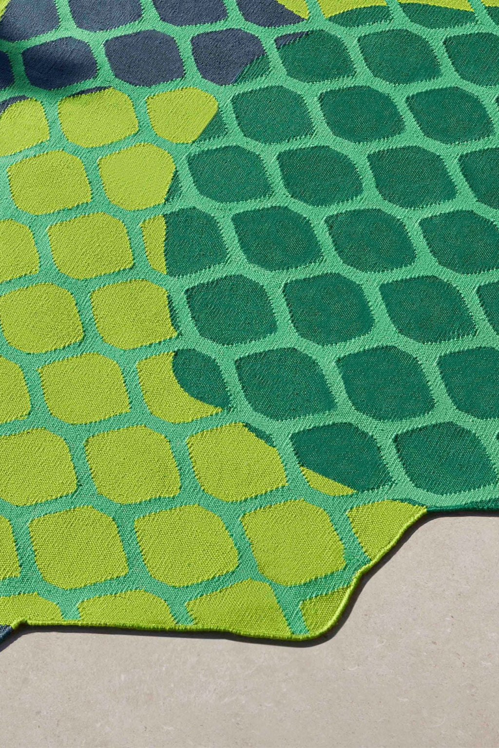GAN Rugs Citrus Outdoor Rug, a vibrant modern rug featuring an abstract organic pattern of rounded shapes in contrasting shades of lime green, forest green, and teal, with subtle dark accents. This durable woven outdoor rug boasts a playful, irregular silhouette, perfect for adding a bold pop of color and contemporary style to a patio, deck, or outdoor living area.