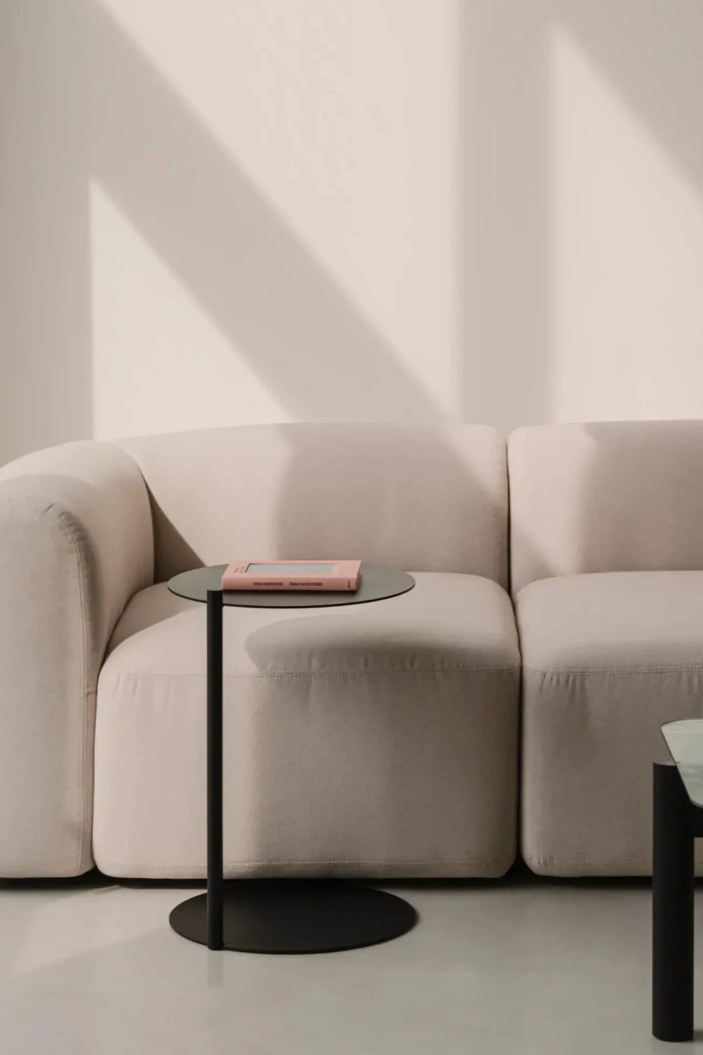 noo.ma Flom 2-Seater Sofa, a modern minimalist sofa with a plush, rounded silhouette and deep seating, upholstered in a soft, light beige fabric.