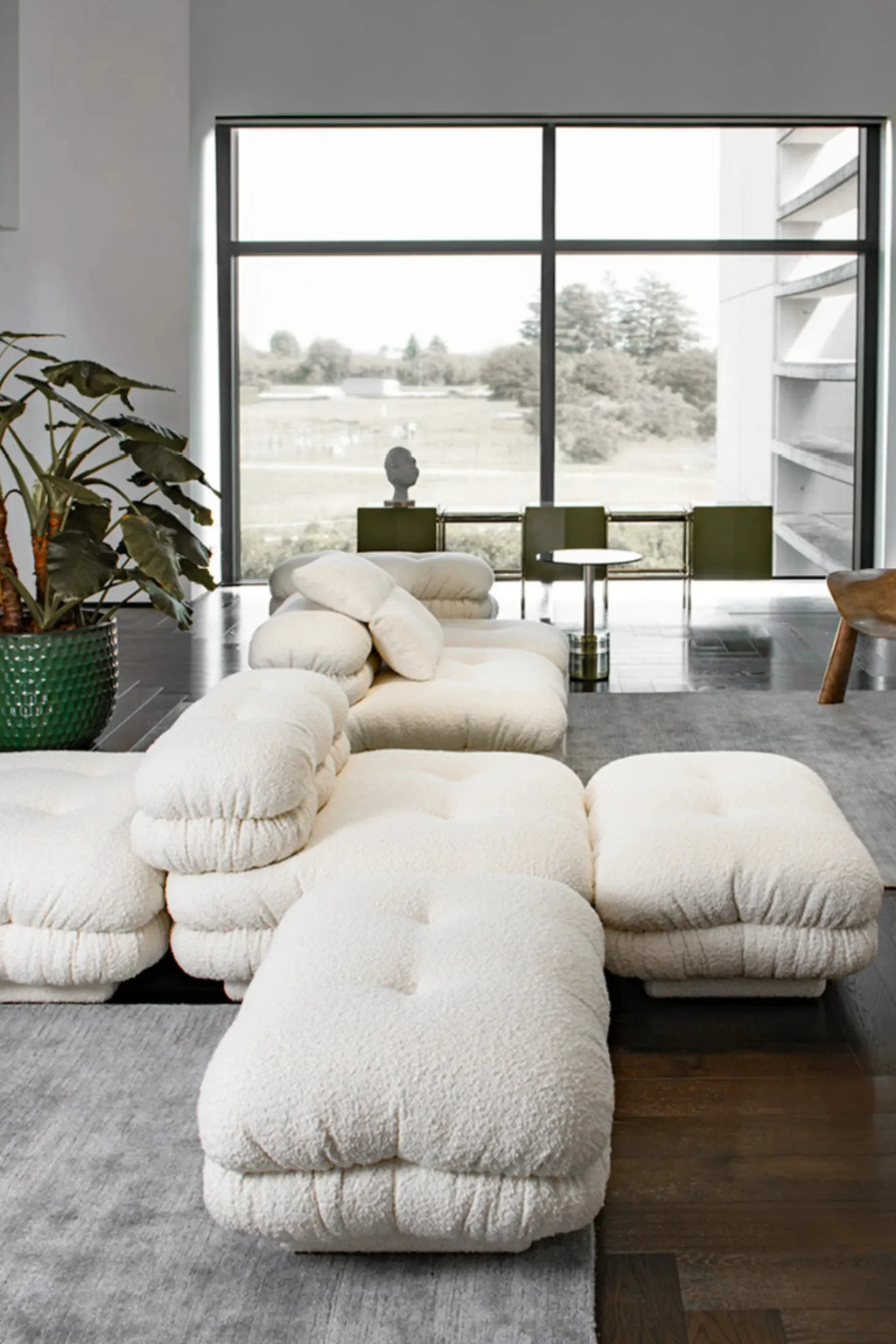 Hessentia Lowell Modular Sofa, a luxurious off-white bouclé fabric sofa featuring plush, deep-seating cushions with subtle tufted details and an inviting low-profile, cloud-like silhouette. This contemporary modular sofa offers versatile comfort and organic modern style for sophisticated living rooms and minimalist lounge spaces.
