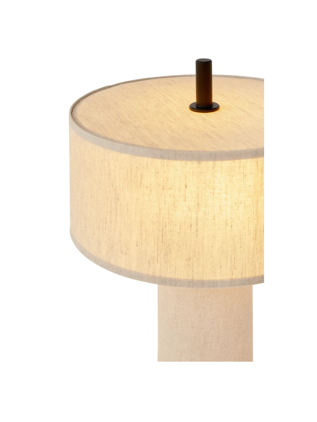 New Works Margin Portable Table Lamp, featuring a warm beige linen drum shade glowing brightly and a dark bronze top detail, displayed on a close-up against white. A premium aesthetic lamp for modern interiors.