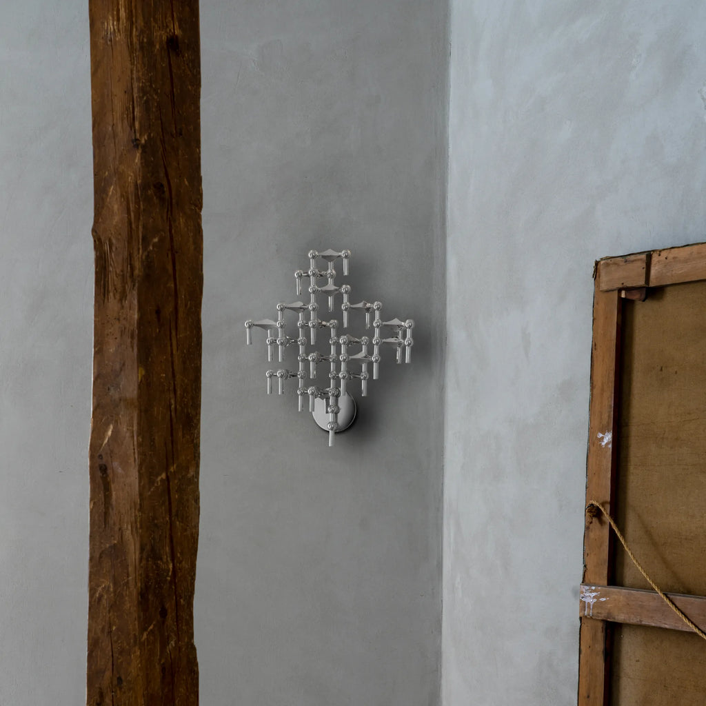 Stoff Nagel Wall Hanger Candle Holder - Chrome - Configuration 3, a striking modular wall-mounted candle holder crafted from polished chrome metal, featuring an intricate geometric and sculptural design with multiple arms. This brutalist-inspired piece functions as both a functional candle display and a bold contemporary wall art statement, ideal for modern living rooms, industrial chic spaces, or mid-century modern decor.
