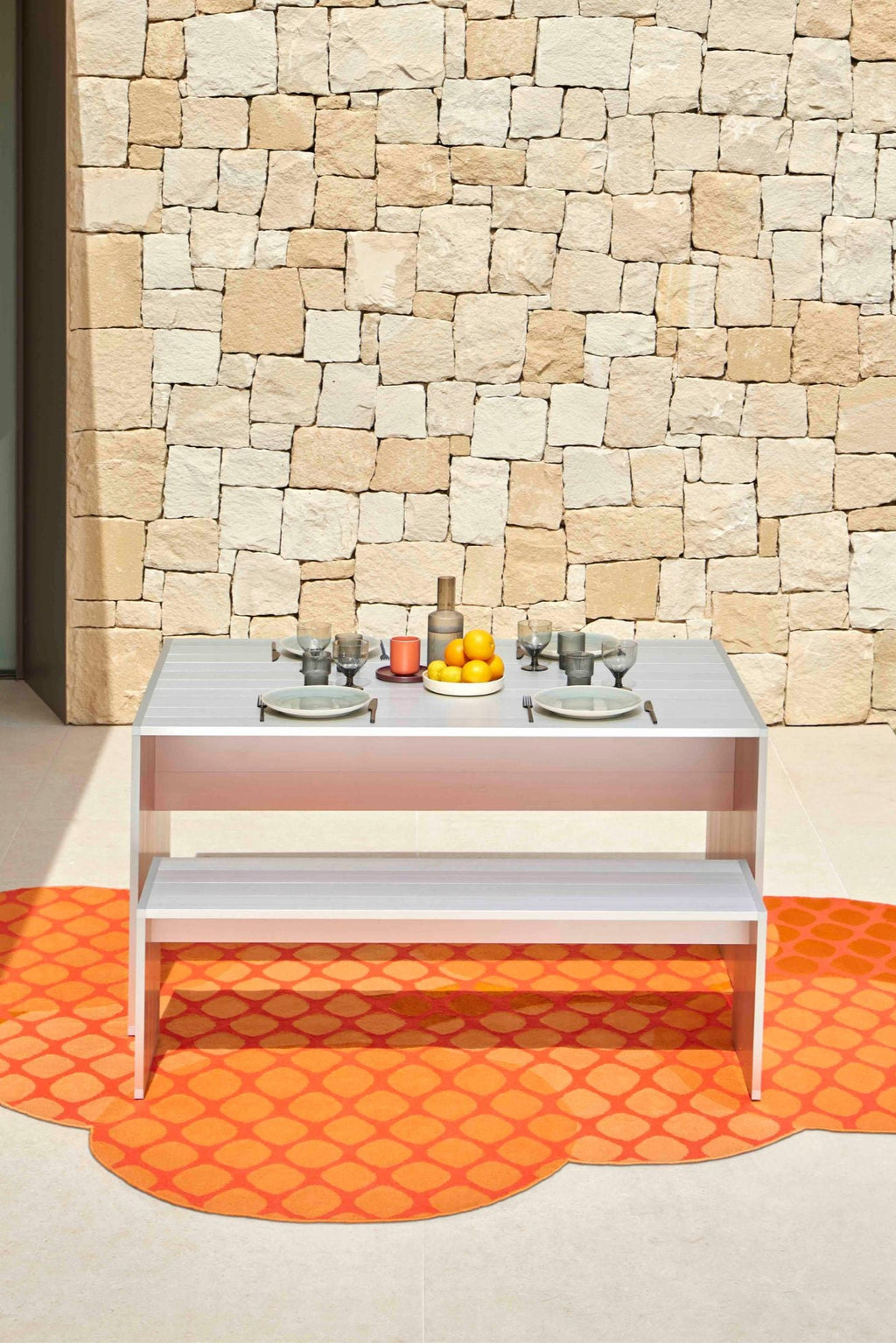 GAN Rugs Citrus Outdoor Rug, a vibrant orange outdoor area rug featuring a playful geometric lattice pattern and a unique irregular cloud-like shape with scalloped edges. Crafted for durability and style, this contemporary outdoor rug is perfect for brightening up patio dining areas, balconies, or Mediterranean-inspired terraces.