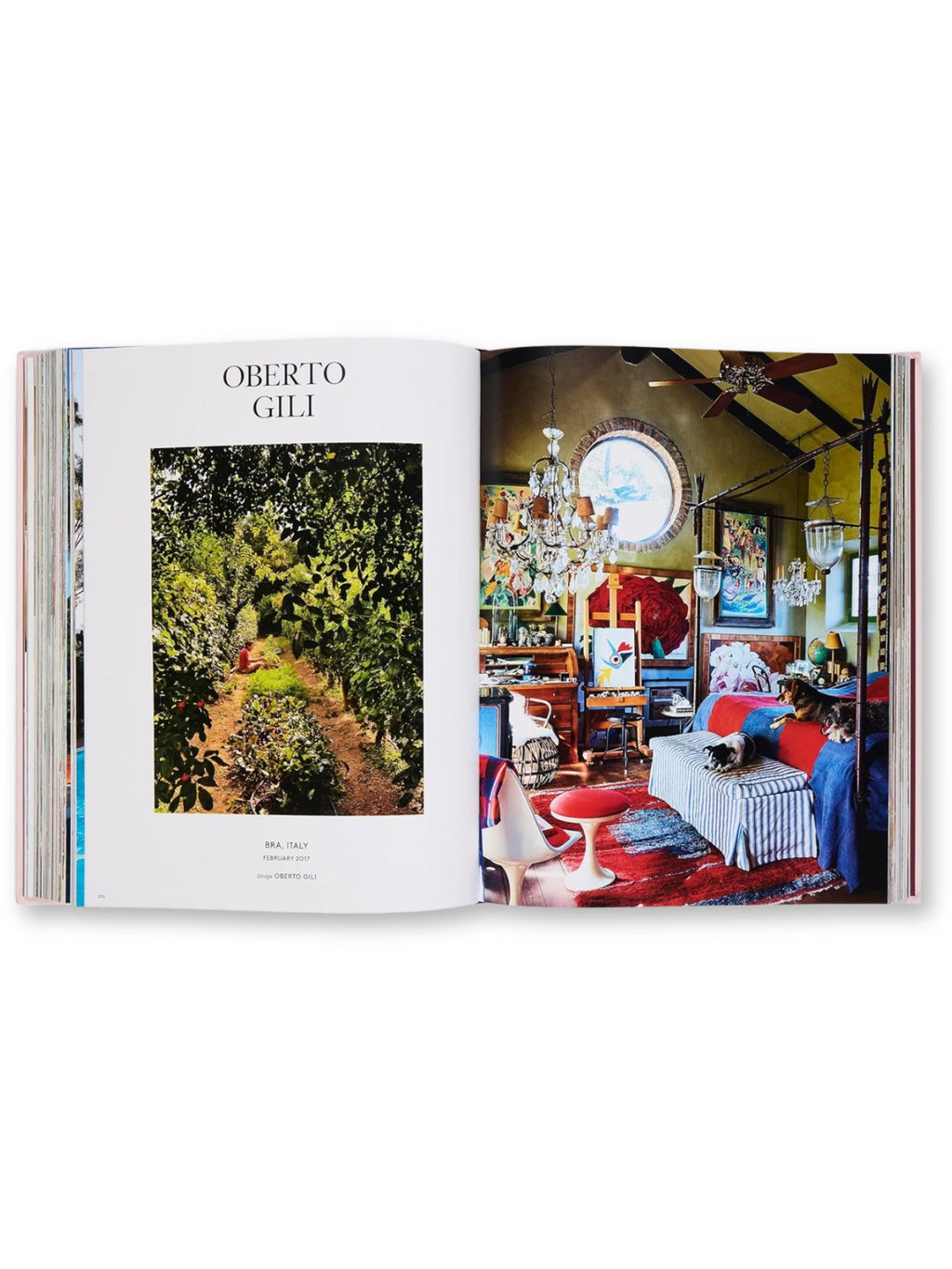 Book AD at Home, an open interior design book showcasing a lush green garden path on the left page and a vibrant, eclectic bedroom with a chandelier, round window, and dogs on the bed on the right. This beautiful coffee table book is perfect for interior design enthusiasts seeking inspiration and visual delight.
