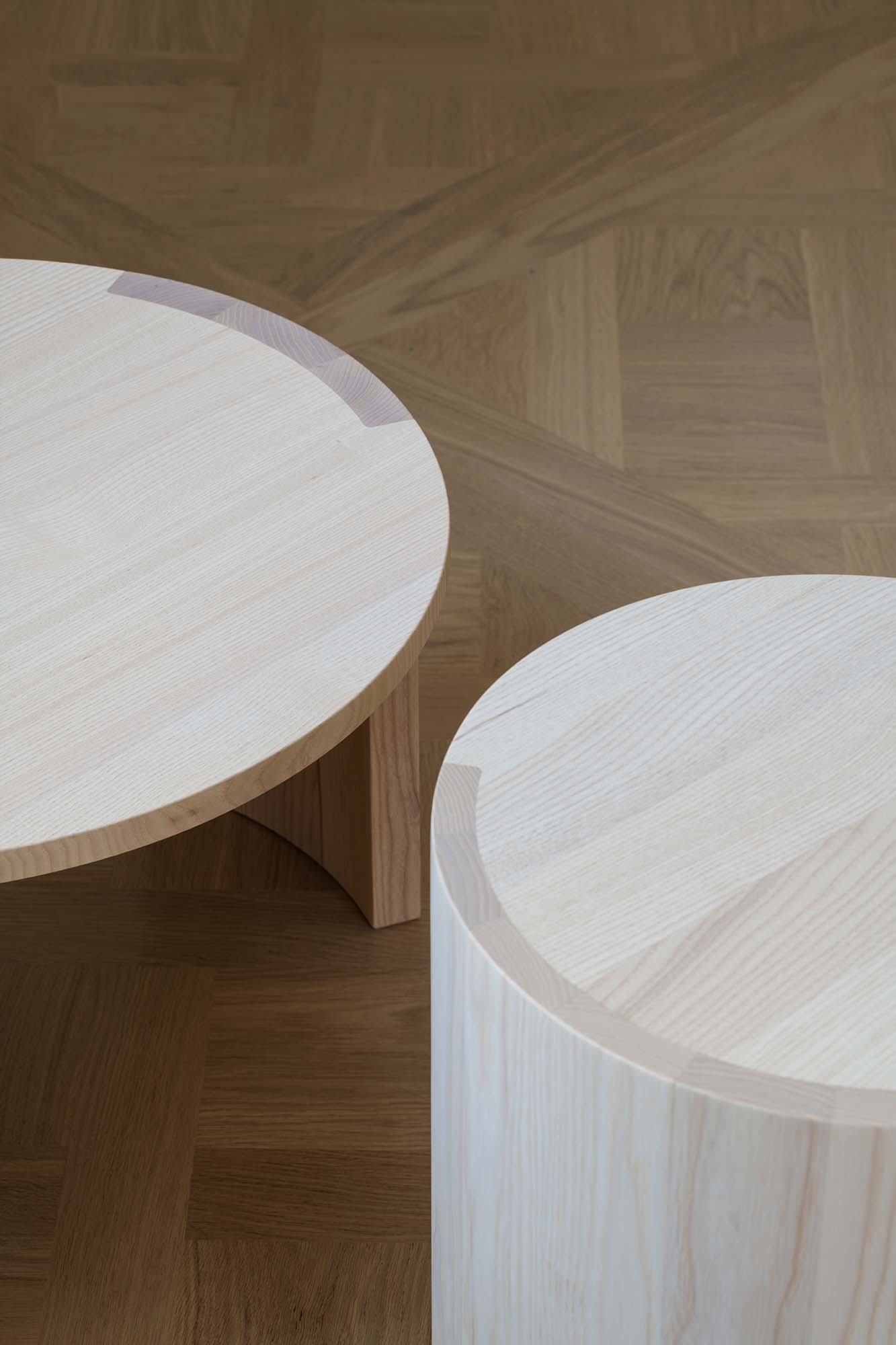 Two wooden coffee tables on a wooden floor.