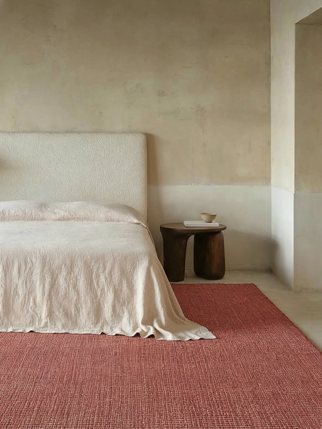 alp_ Al Jumra Rug, a rich terracotta red natural fiber area rug featuring a dense, hand-woven textured weave with subtle color variations, creating a rustic yet refined aesthetic. This organic modern rug is perfect for adding warmth to a minimalist bedroom, living room, or natural home decor.