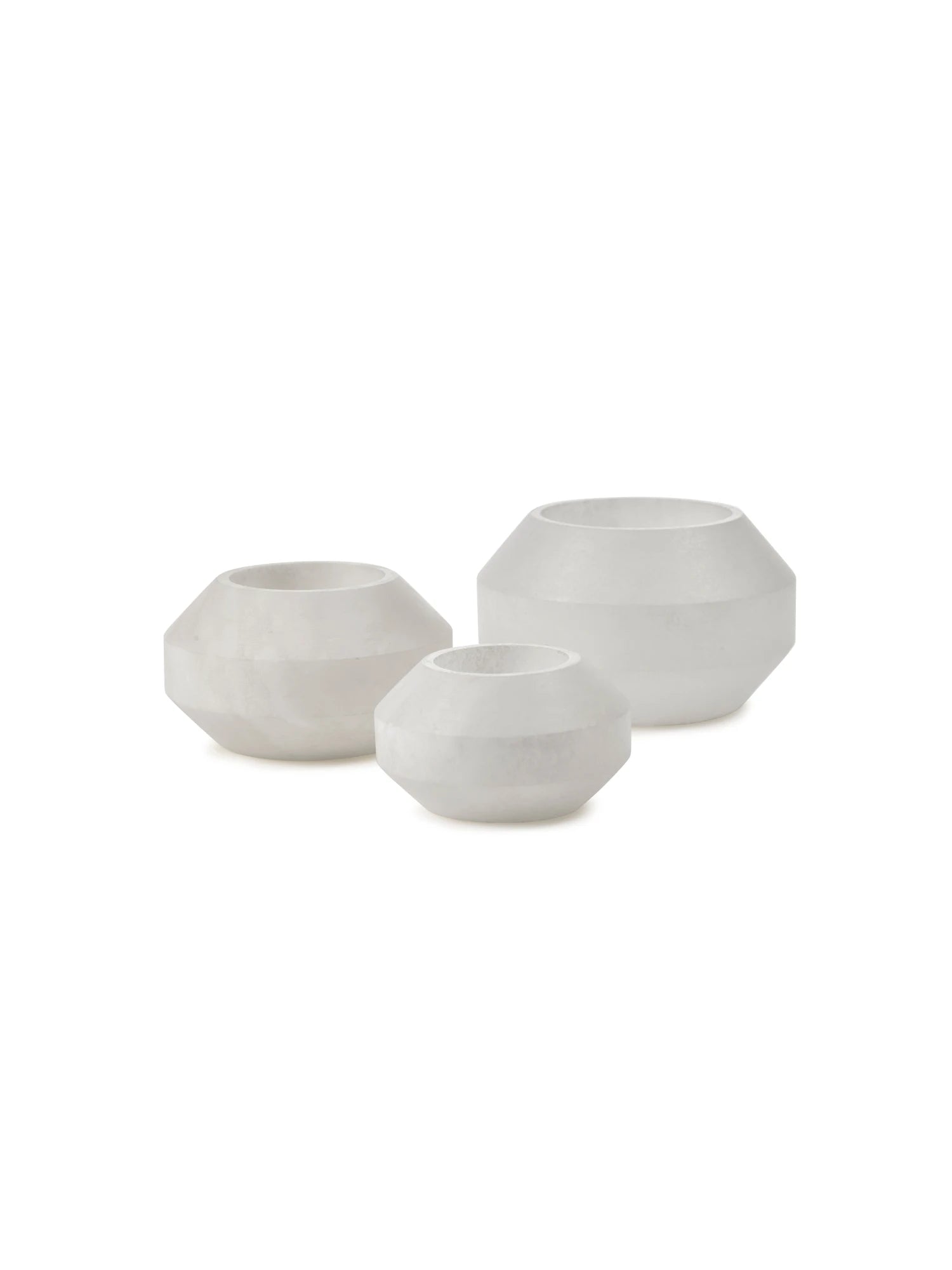 Three alabaster candle holder of different sizes on a white background
