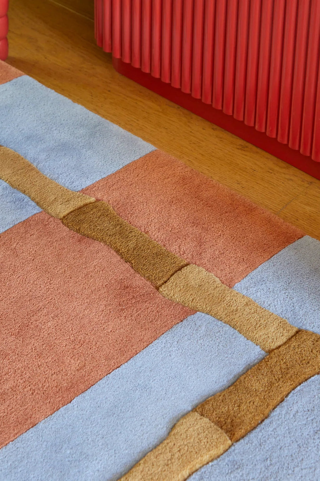 Layered Bamboo Stripe Wool Rug, a modern geometric area rug with light blue, peach, and brown color blocks and a textured golden yellow stripe. Perfect for adding contemporary style and warmth to a...