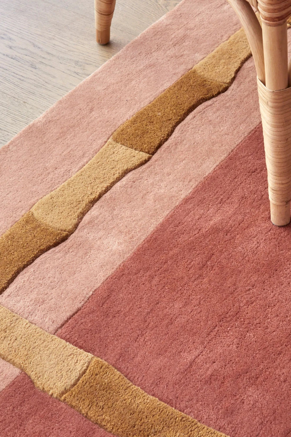 Layered Bamboo Stripe Wool Rug, a plush area rug featuring organic-shaped stripes in shades of pink, rose, and natural brown wool. Perfect for adding warm, textural comfort to living rooms or bedro...