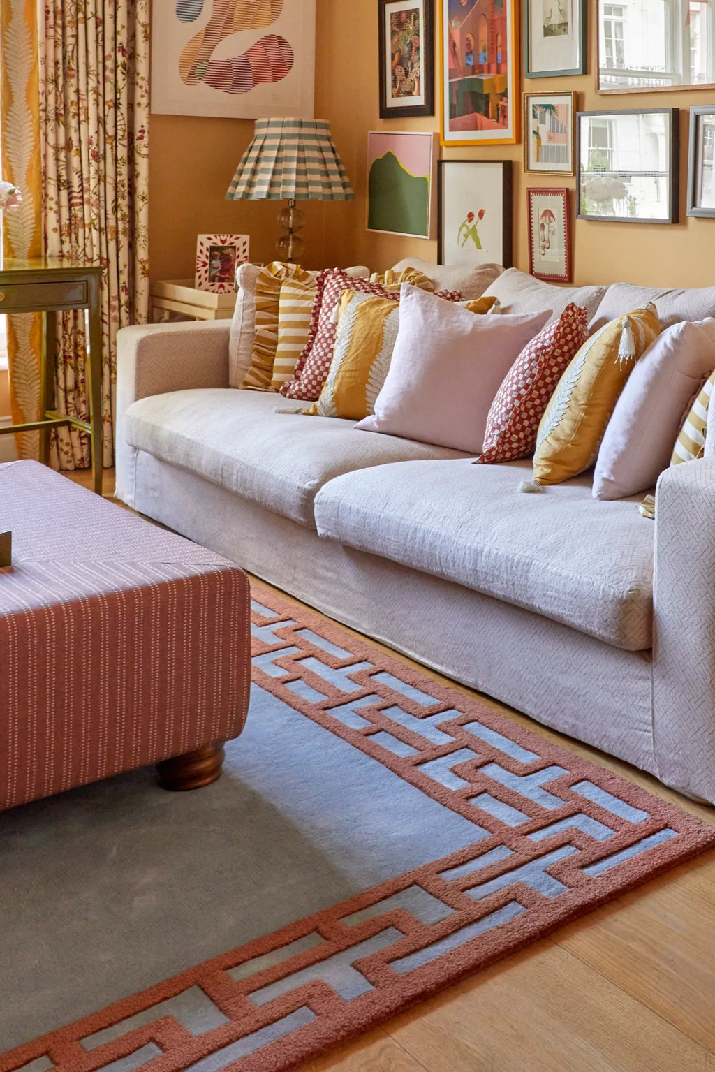 Layered Indocine Wool Rug, a luxurious light blue area rug with a bold rust orange Greek key border, offering a modern geometric design. Perfect for elevating living room decor and adding sophistic...