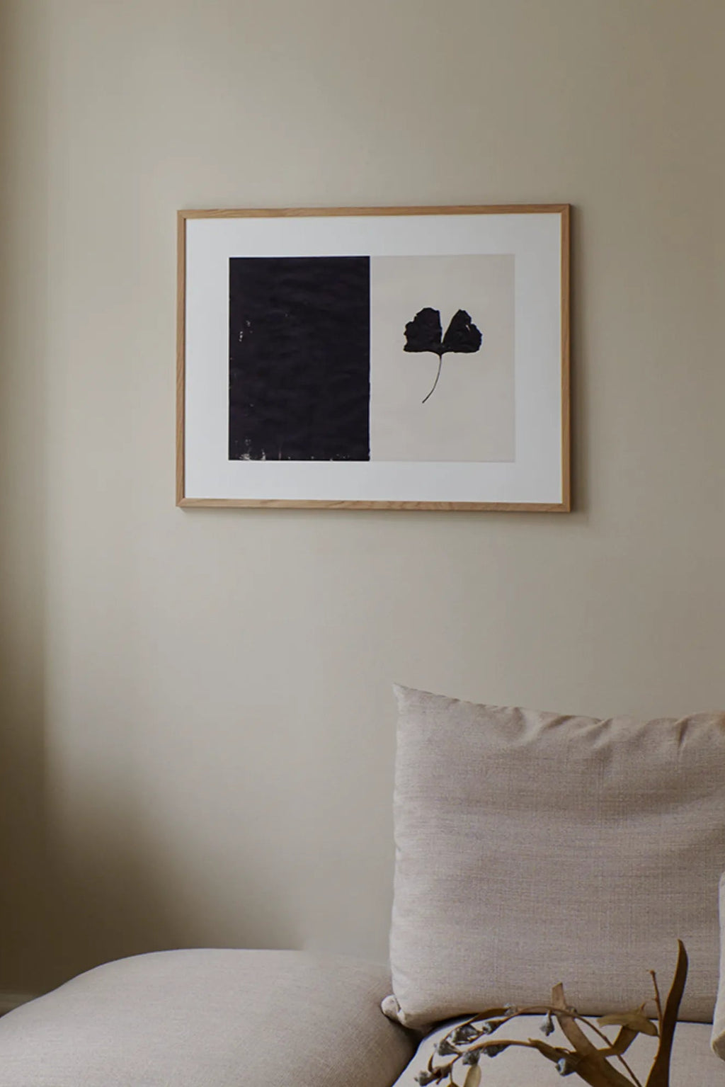 The Poster Club Black Ginkgo, a striking modern minimalist art print featuring a bold black ginkgo leaf silhouette against a creamy white background, juxtaposed with a textured black abstract block. This organic botanical poster is elegantly framed in a light natural oak frame with a crisp white mat. Perfect as contemporary wall art for Scandinavian living rooms, japandi bedrooms, or minimalist home offices.