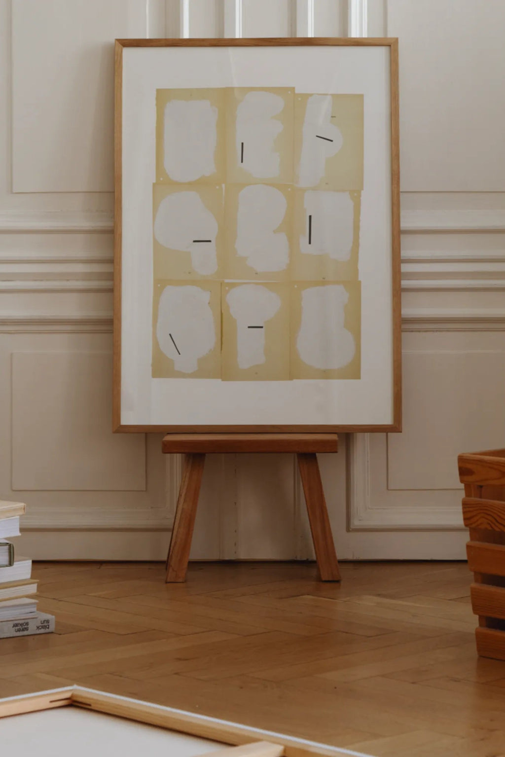 The Poster Club Cover, a minimalist abstract art print featuring nine organic white shapes with short black line accents, set against a light beige background within a crisp white mat. This contemporary poster is encased in a natural light oak frame, perfect as modern wall art for Scandinavian living rooms, Japandi bedrooms, or a clean gallery wall.