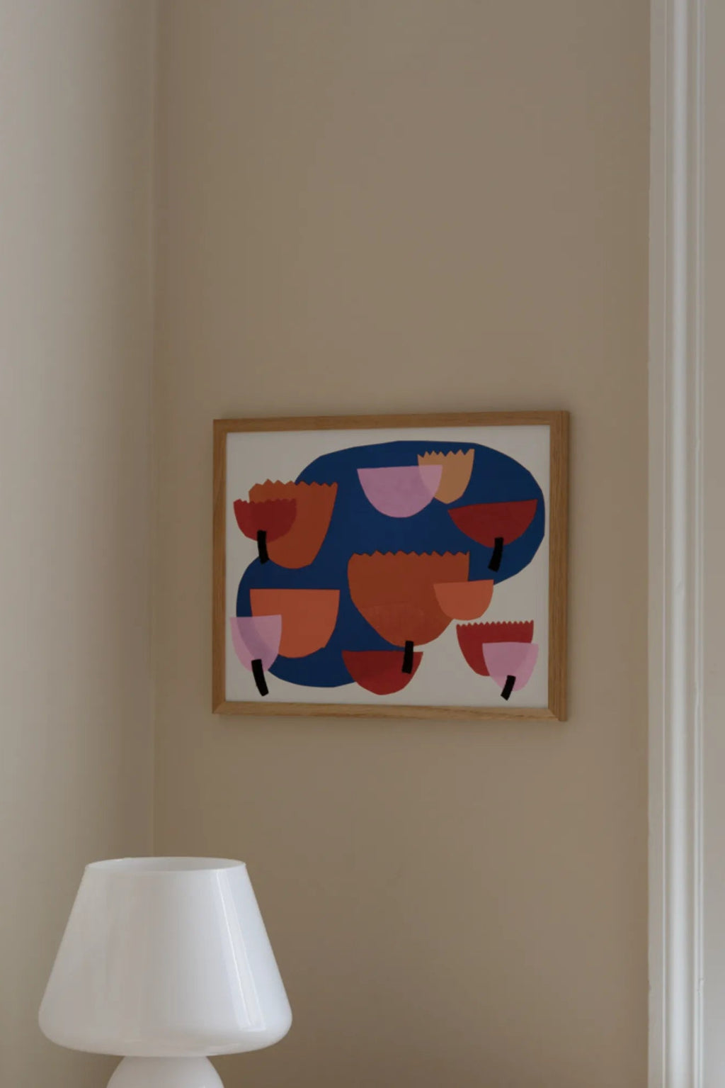 The Poster Club Dew, a vibrant abstract art print featuring organic shapes in royal blue, terracotta orange, deep red, and light pink, with subtle black accents, set against a crisp white background. This contemporary graphic poster is presented in a clean natural oak frame. Perfect as modern wall art for a colorful living room, minimalist bedroom, or a curated gallery wall.