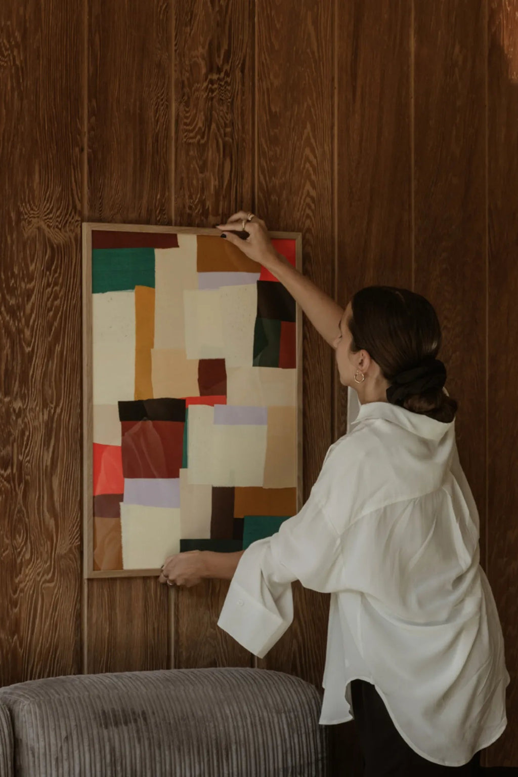 The Poster Club Fields, a multi-color abstract art print featuring a collage of layered geometric shapes in earthy tones like cream, mustard yellow, deep red, forest green, and dark brown. This contemporary wall art is beautifully framed in a light natural oak wood frame, offering an organic texture. Perfect as modern art for a living room, bedroom, or gallery wall, adding warmth to minimalist or Scandinavian-inspired interiors.