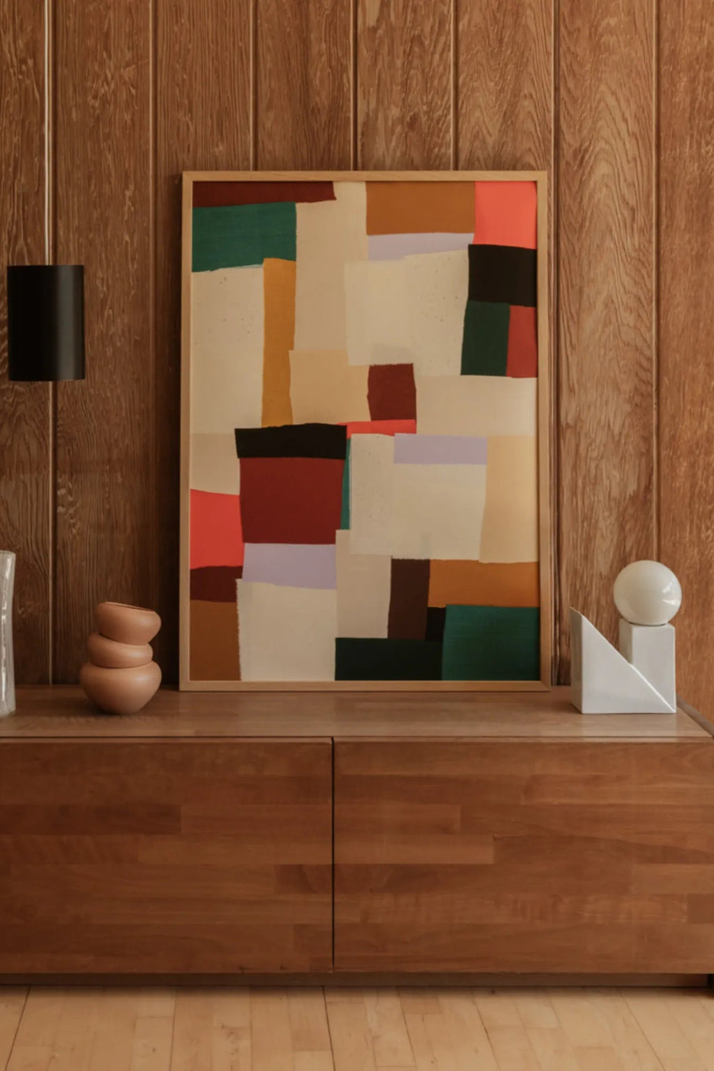 The Poster Club Fields, a vibrant abstract art print featuring painterly blocks of color in deep red, forest green, coral pink, mustard yellow, light lavender, cream, black, and warm brown, framed in a light natural oak frame. This modern rectangular wall art is perfect for contemporary living rooms or organic modern gallery walls and adds a touch of colorful abstract wall decor.