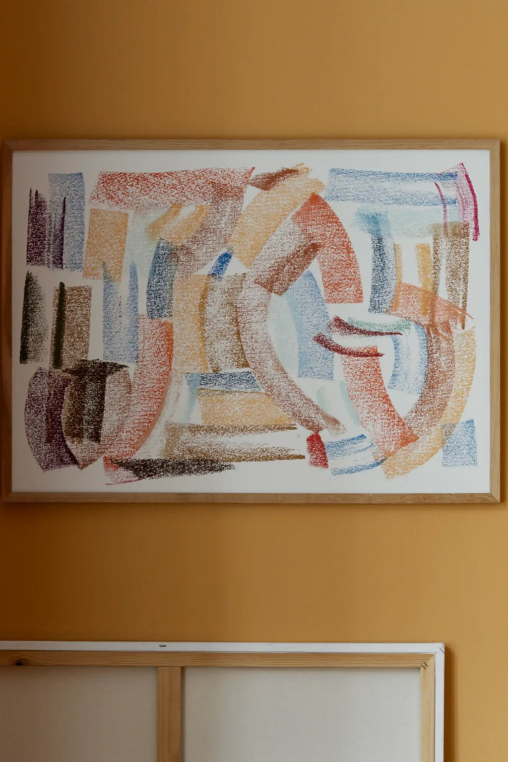 The Poster Club Sunset, an abstract art print featuring expressive, painterly strokes and blocks in a warm multi-color palette of terracotta, rust red, golden yellow, muted blue, and deep brown on a cream background, framed in a natural oak frame. This contemporary wall art is perfect for adding an organic modern touch to living rooms, bedrooms, or gallery walls.